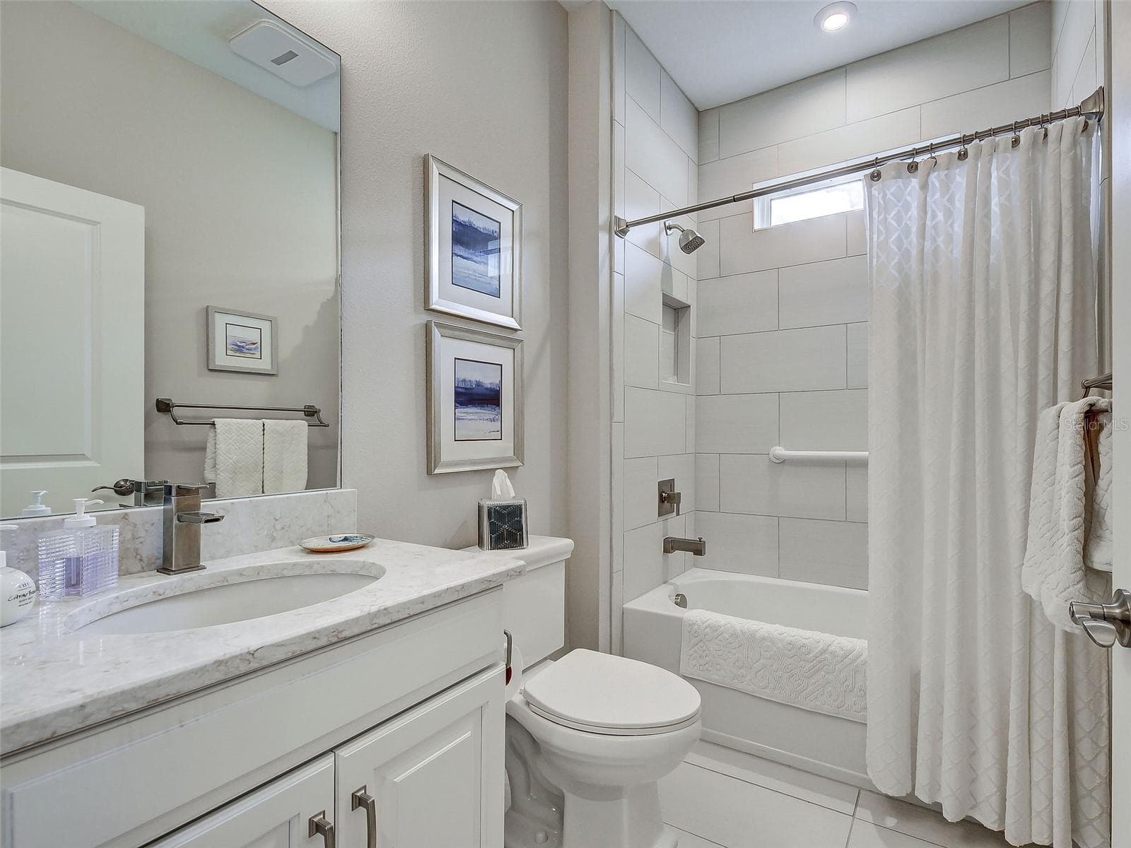 The guest bathroom has a tub/shower combination. - 5616 SCARLOTTI ST, NOKOMIS