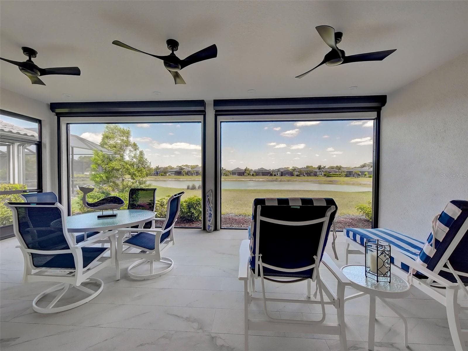 Enjoy the unobstructed view from the Florida room with modern ceiling fans and Nautilus Rolling Hurricane Screens - 5616 SCARLOTTI ST, NOKOMIS