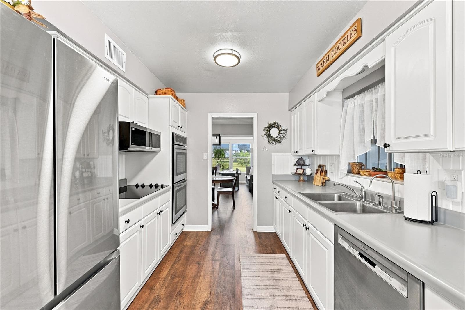 Beautiful Laminate Oak Plank Flooring, Updated Efficient Galley Kitchen, New Fixtures, Interior Repainted, New Refrigerator & Microwave, Coffee Bar, & Eat-In Kitchen - 1405 HACIENDA DR, SUN CITY CENTER