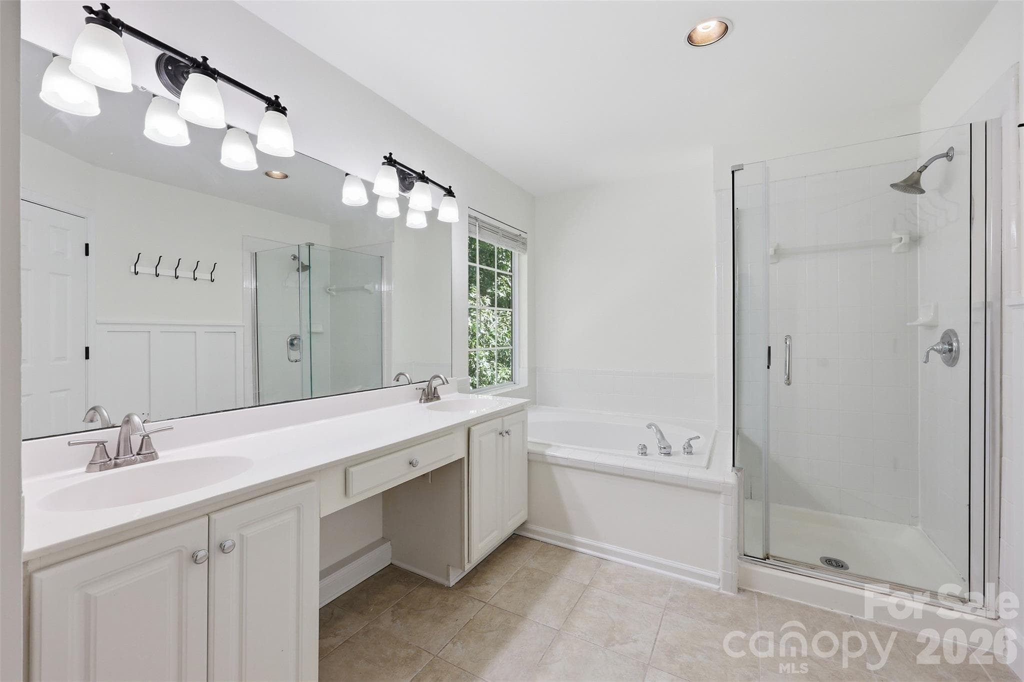 Primary bath features a dual sink vanity, a relaxing soaking tub, and a separate walk-in shower! - 6832 Charter Hills Road, Charlotte