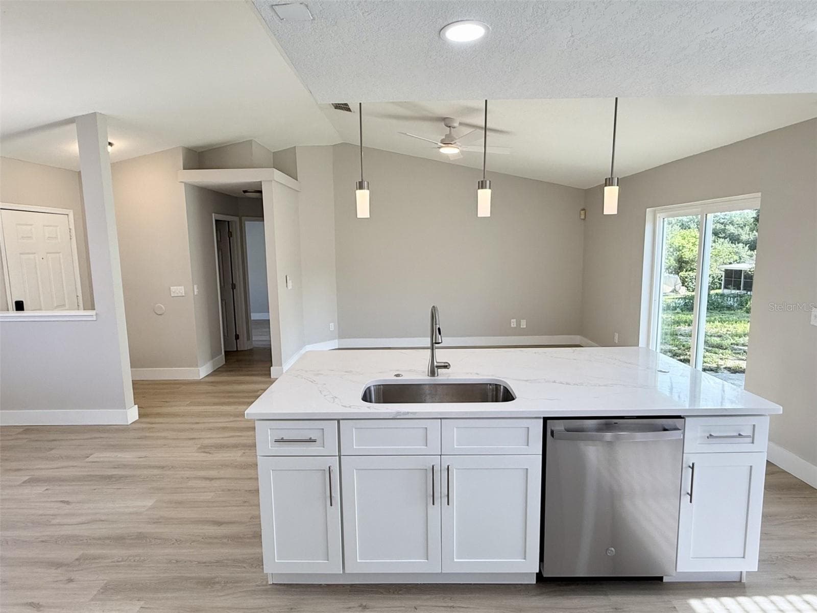 Full redesigned Kitchen is open to Living Room with brand new 42" cabinets, quartz countertops, enormous center island with double sided cabinets, marble tile backsplash, new stainless steel appliances and breakfast nook. - 10814 CRESCENDO LOOP, CLERMONT