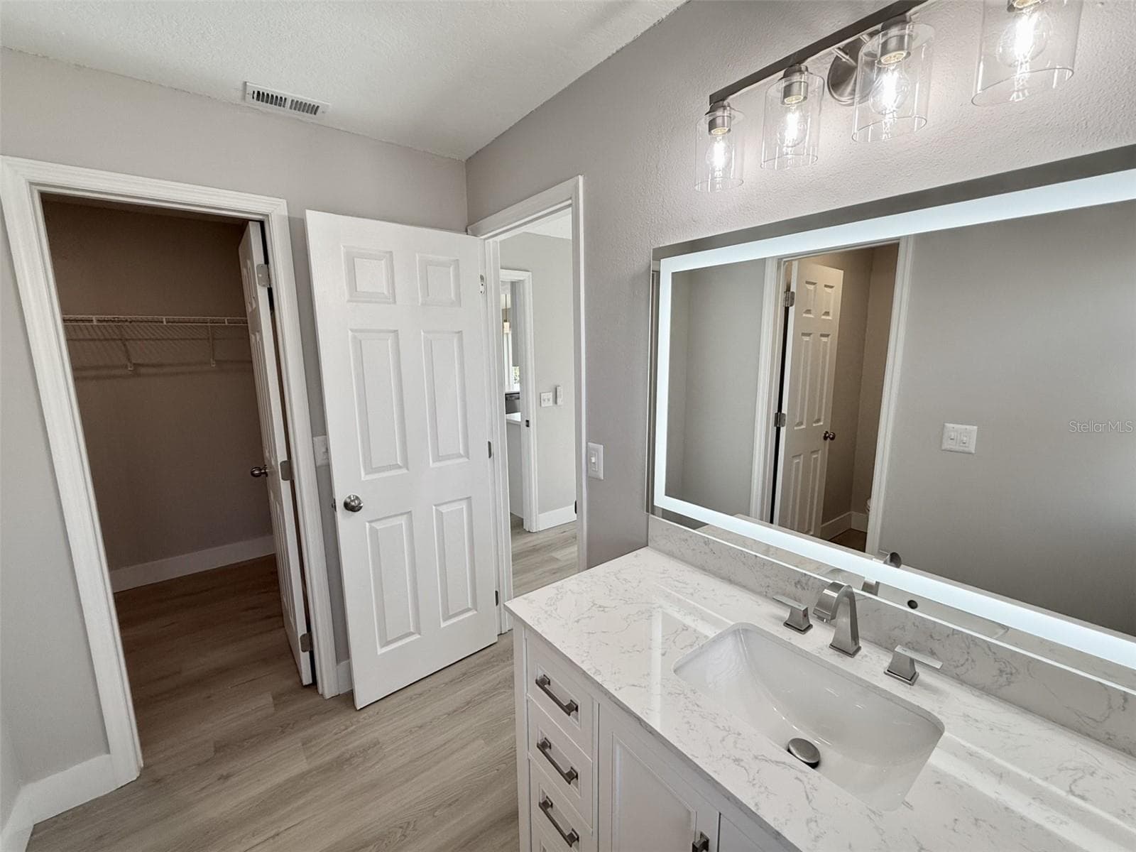 Primary Bath with walk-in closet, new stand alone quartz vanity, anti-fog LED mirror and marble tiled shower - 10814 CRESCENDO LOOP, CLERMONT