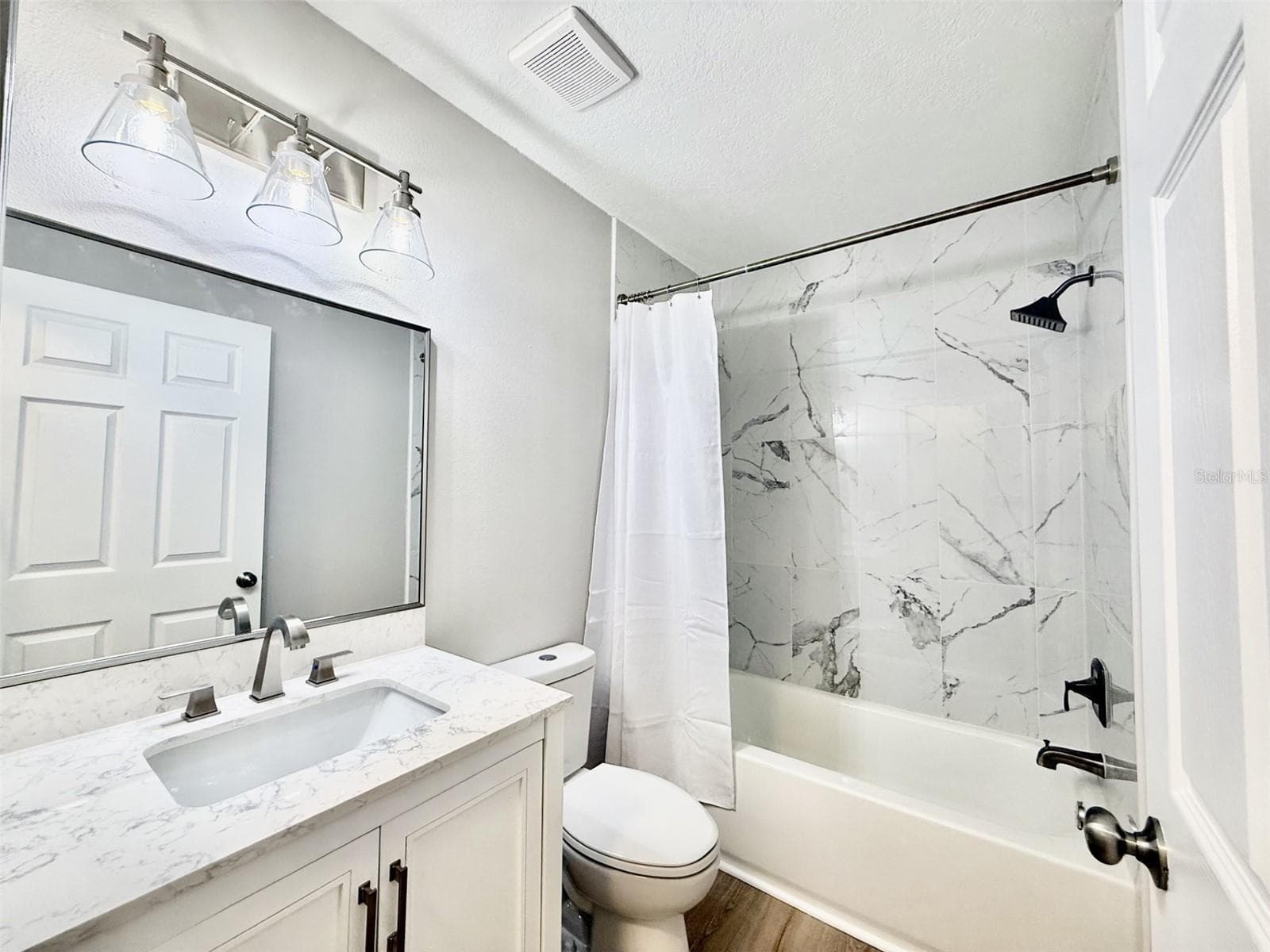 Hallway bath with quartz vanity and marble tiled shower/tub combo - 10814 CRESCENDO LOOP, CLERMONT