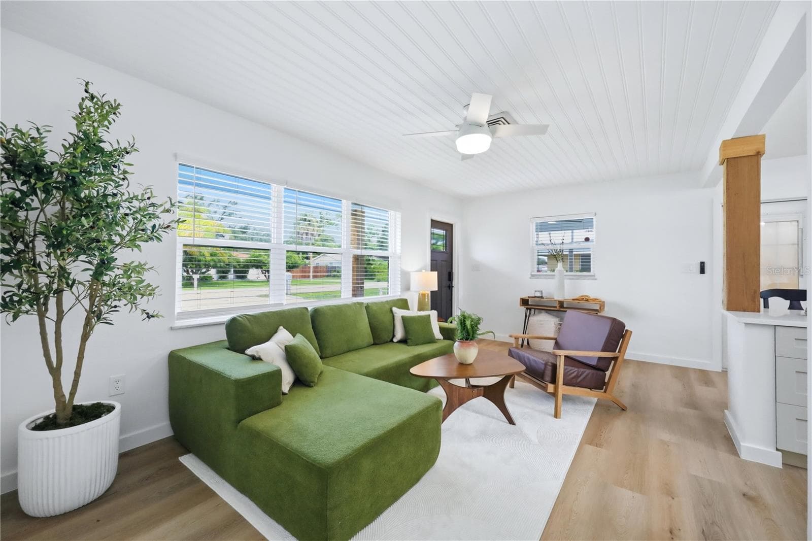Bright open living room with new laminate flooring and updated interior finishes - 6103 CARLTON AVE, SARASOTA
