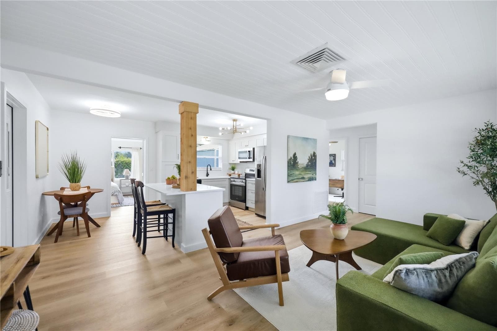 Open-concept living space with new laminate flooring, natural light and updated finishes - 6103 CARLTON AVE, SARASOTA