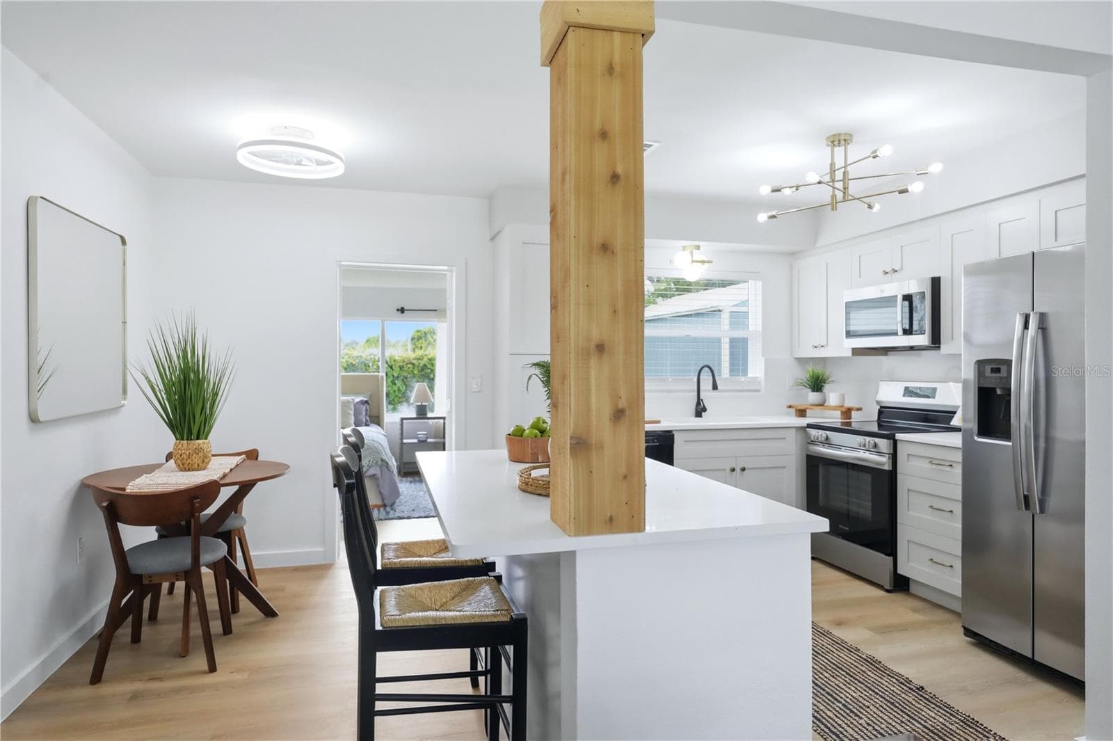 Open kitchen and dining area with large island, stainless appliances and updated cabinetry - 6103 CARLTON AVE, SARASOTA