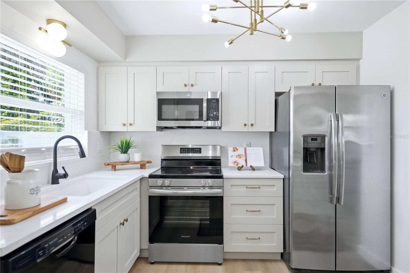 Renovated kitchen with white cabinetry, stainless appliances and large center island, updated lighting - 6103 CARLTON AVE, SARASOTA
