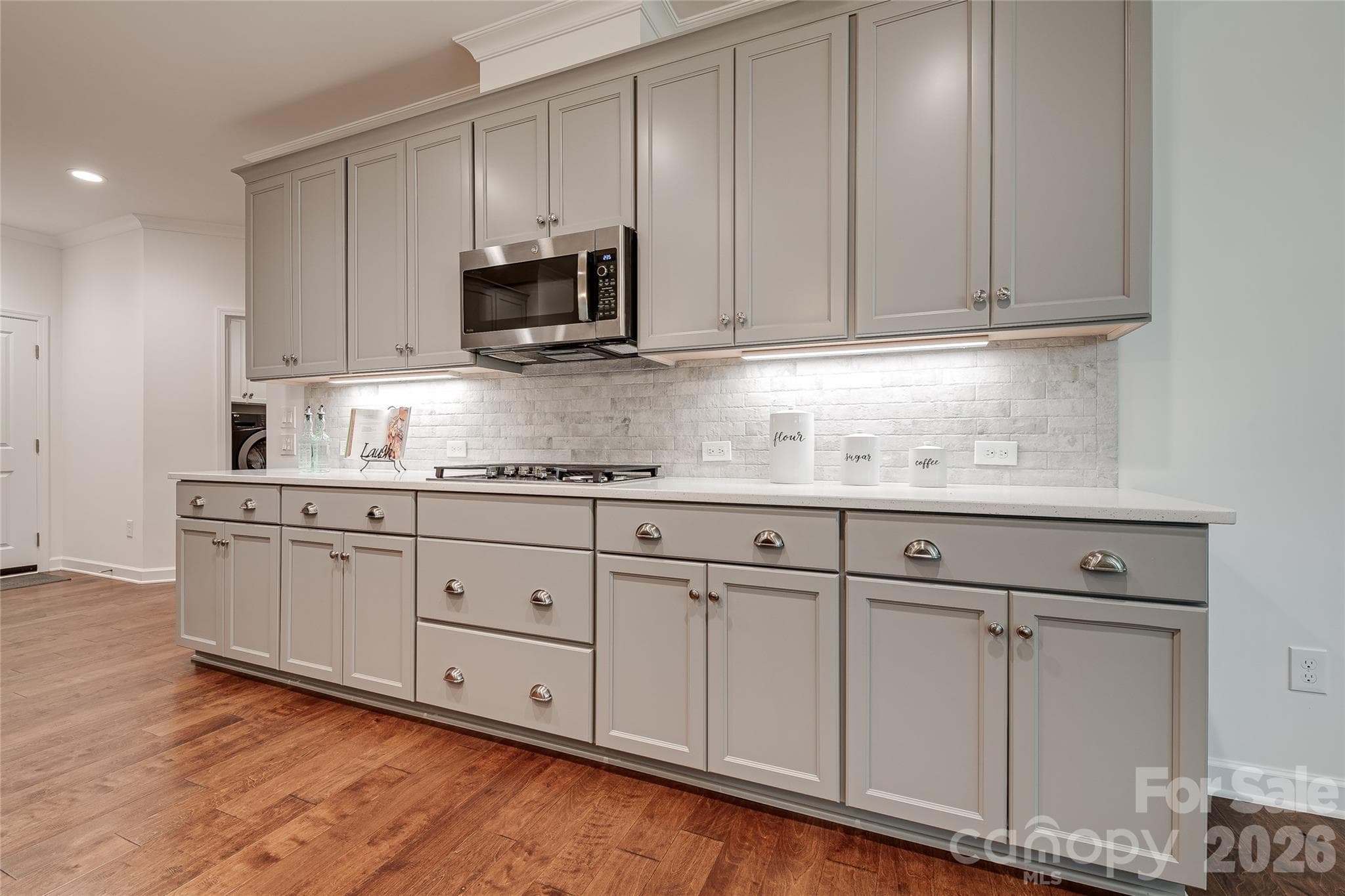 Beautiful painted maple cabinetry with crown moulding, under cabinet lighting and a gas cooktop. - 2566 NW Red Hill Street, Concord