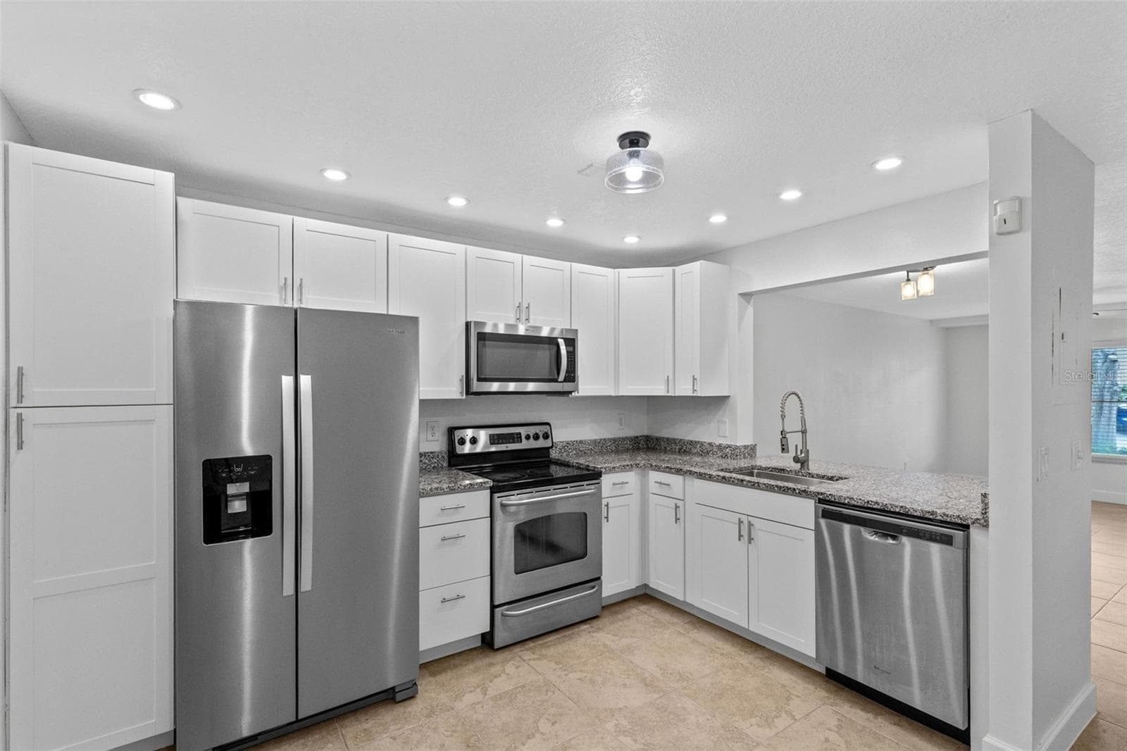 The updated kitchen features white cabinetry, granite countertops, stainless steel appliances and a breakfast bar overlooking the living and dining space. Interior laundry, washer and dryer included, and an additional downstairs storage closet complete the first floor. - 283 SANDLEWOOD TRL #3, WINTER PARK