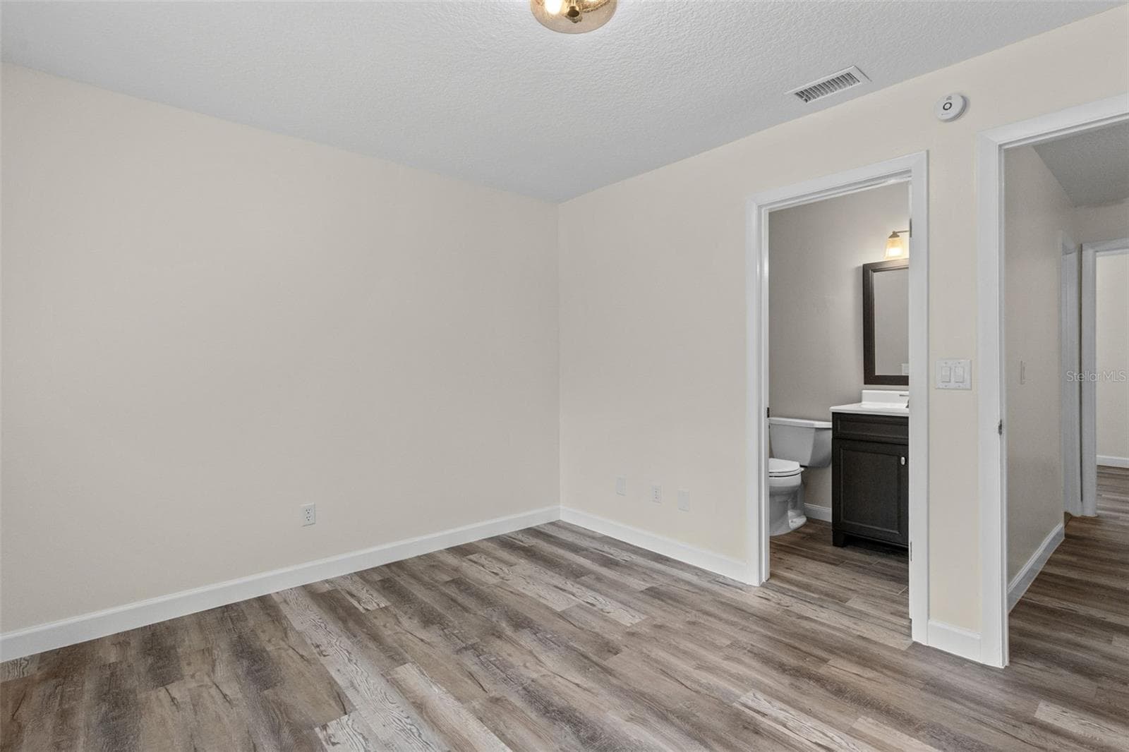 Upstairs, the primary bedroom features a private en suite bathroom - 283 SANDLEWOOD TRL #3, WINTER PARK