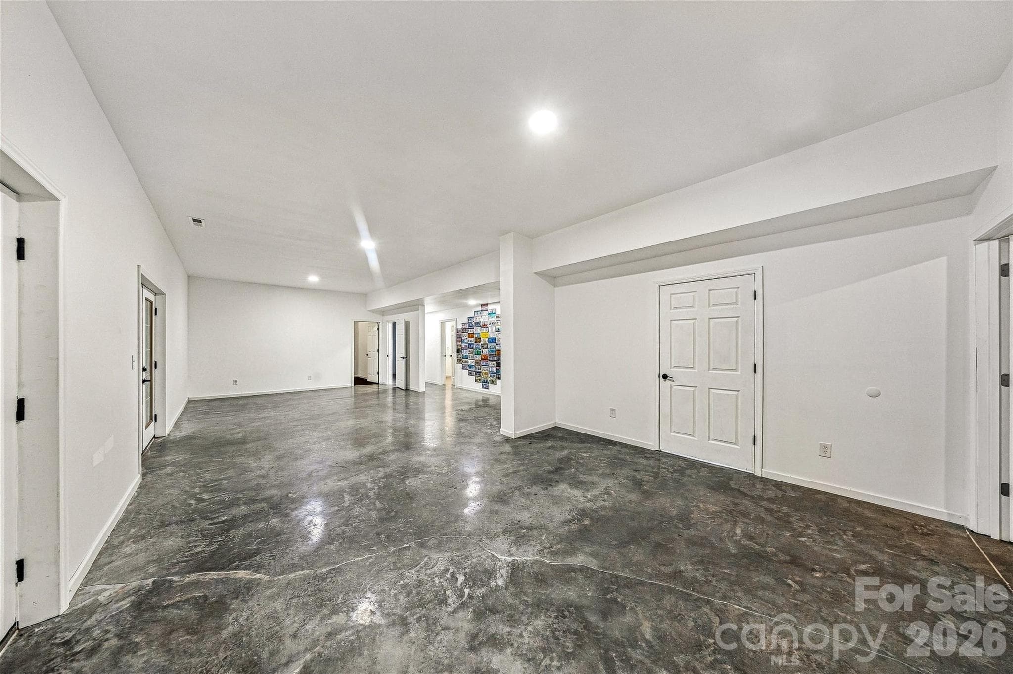 Clean Palate - concrete floors - double doors walk out. Waiting for your design! Plenty of storage. Fitness room and Spa room on this level. - 90 Ashley Woods Drive, Arden