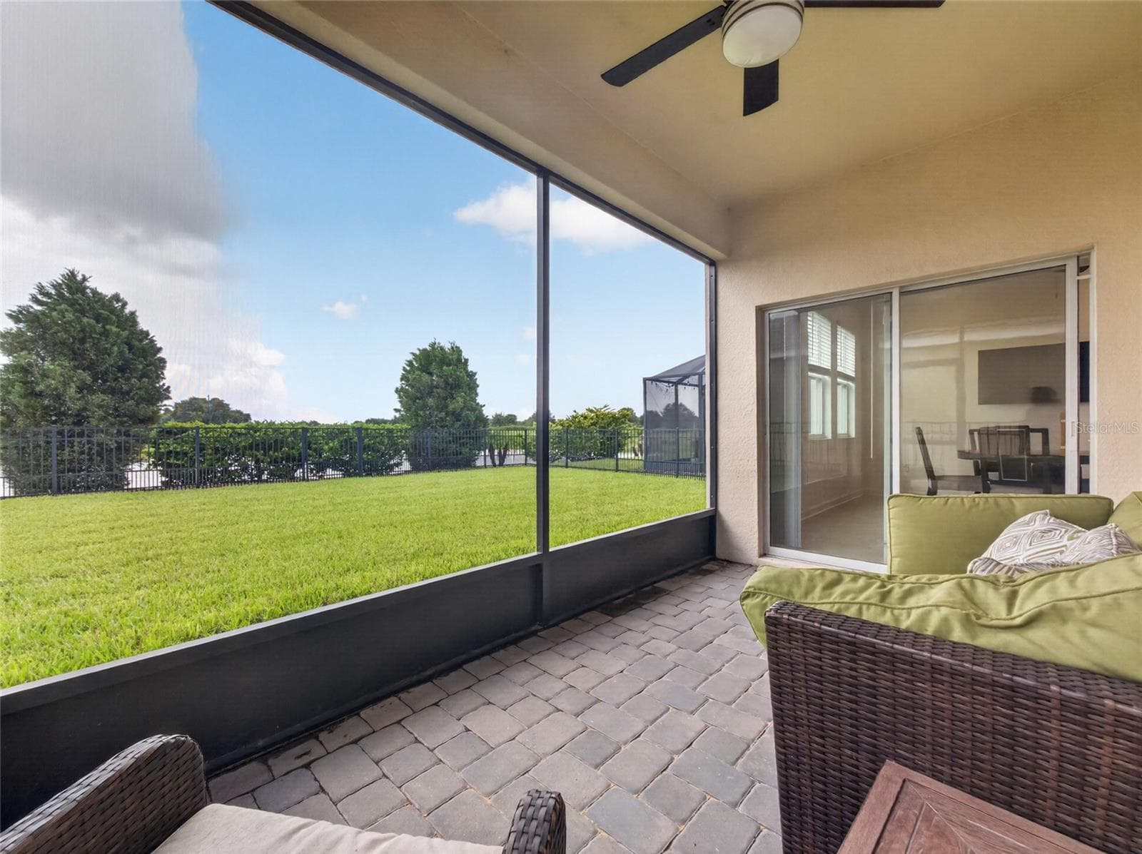 Screened-in pavered lanai overlooking a fully fenced backyard with beautiful golf course views—the perfect spot to relax and enjoy Florida living. - 8813 BETH PAGE LN, DAVENPORT
