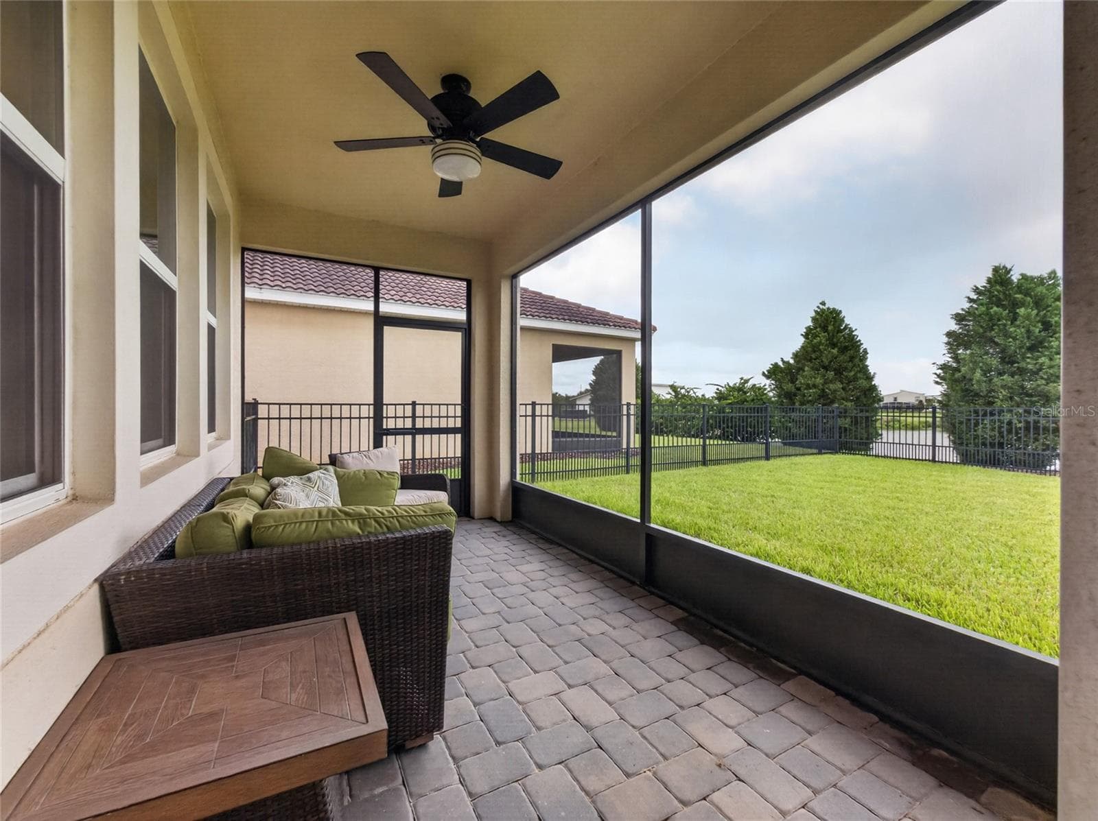 Screened-in pavered lanai overlooking a fully fenced backyard with beautiful golf course views—the perfect spot to relax and enjoy Florida living. - 8813 BETH PAGE LN, DAVENPORT