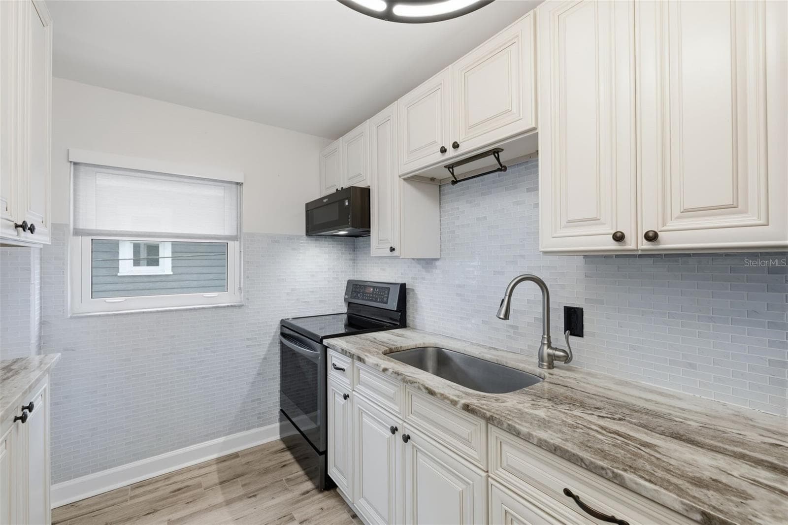 The refreshed kitchen features newer finishes, updated tile, and a window that brings natural light into the space. - 841 4TH AVE N #27, ST PETERSBURG