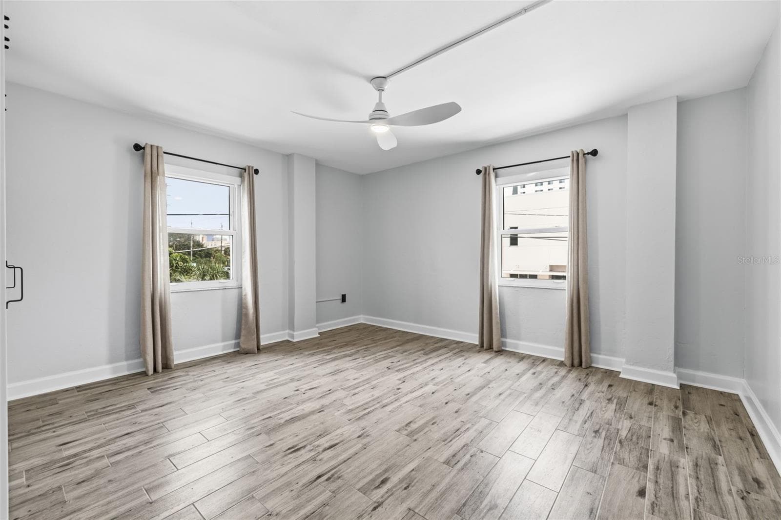 The spacious bedroom features multiple windows, newer tile flooring, and a ceiling fan for added comfort. - 841 4TH AVE N #27, ST PETERSBURG