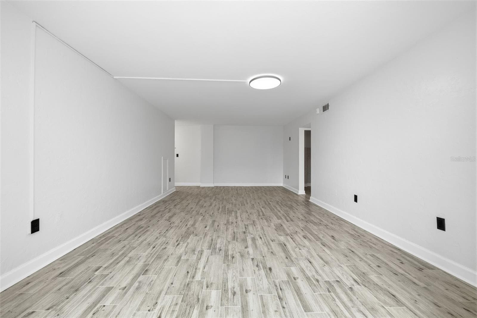 Spacious living area with fresh paint, new tile flooring, and a long, open layout offering plenty of flexibility for comfortable seating and entertaining. - 841 4TH AVE N #27, ST PETERSBURG