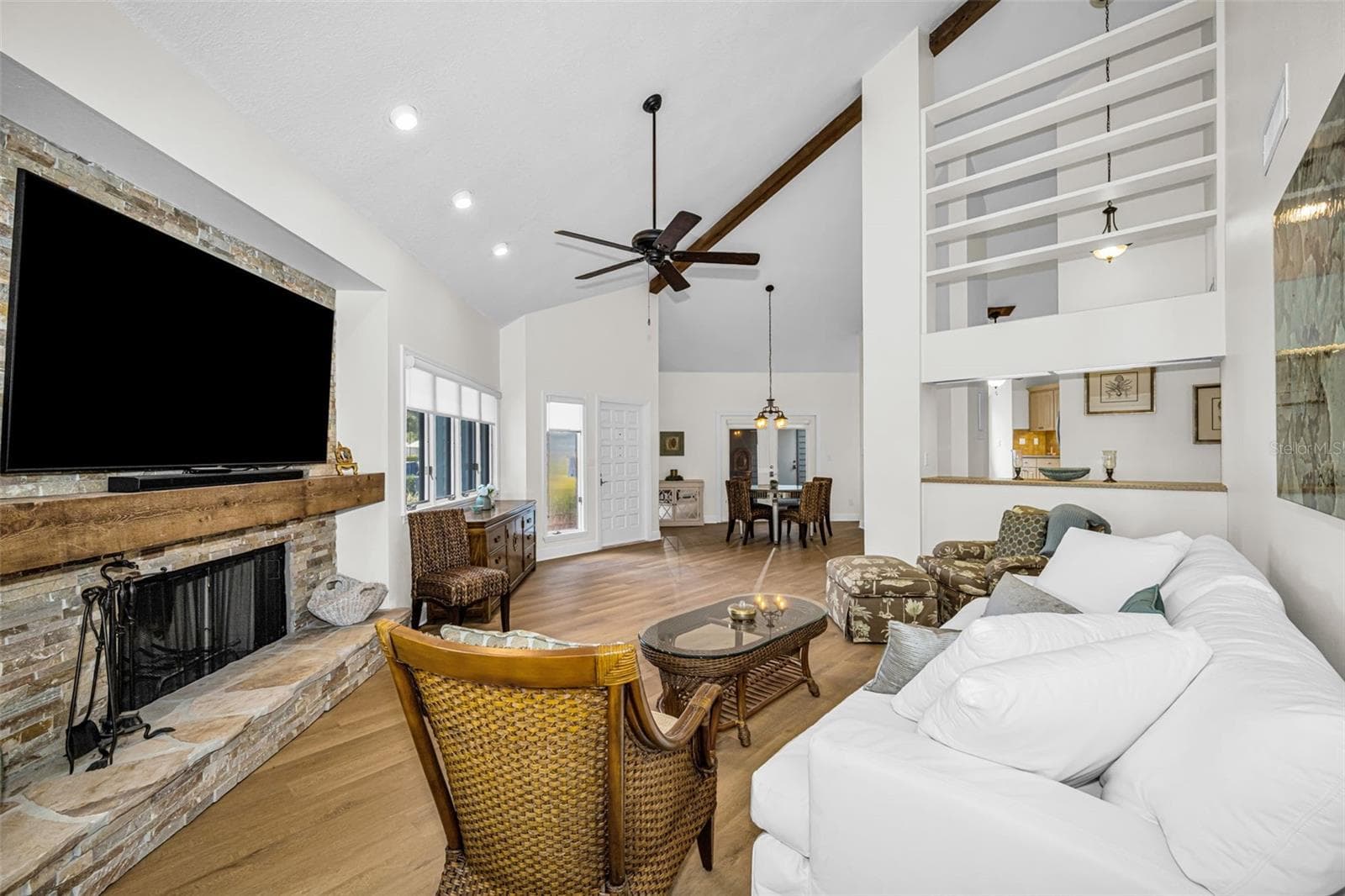 Living room view, looking towards the front door. Note the wide open space and wonder natural light! Open cabinets and walls allow for great displays of your treasures! - 10479 LONGWOOD DR, SEMINOLE