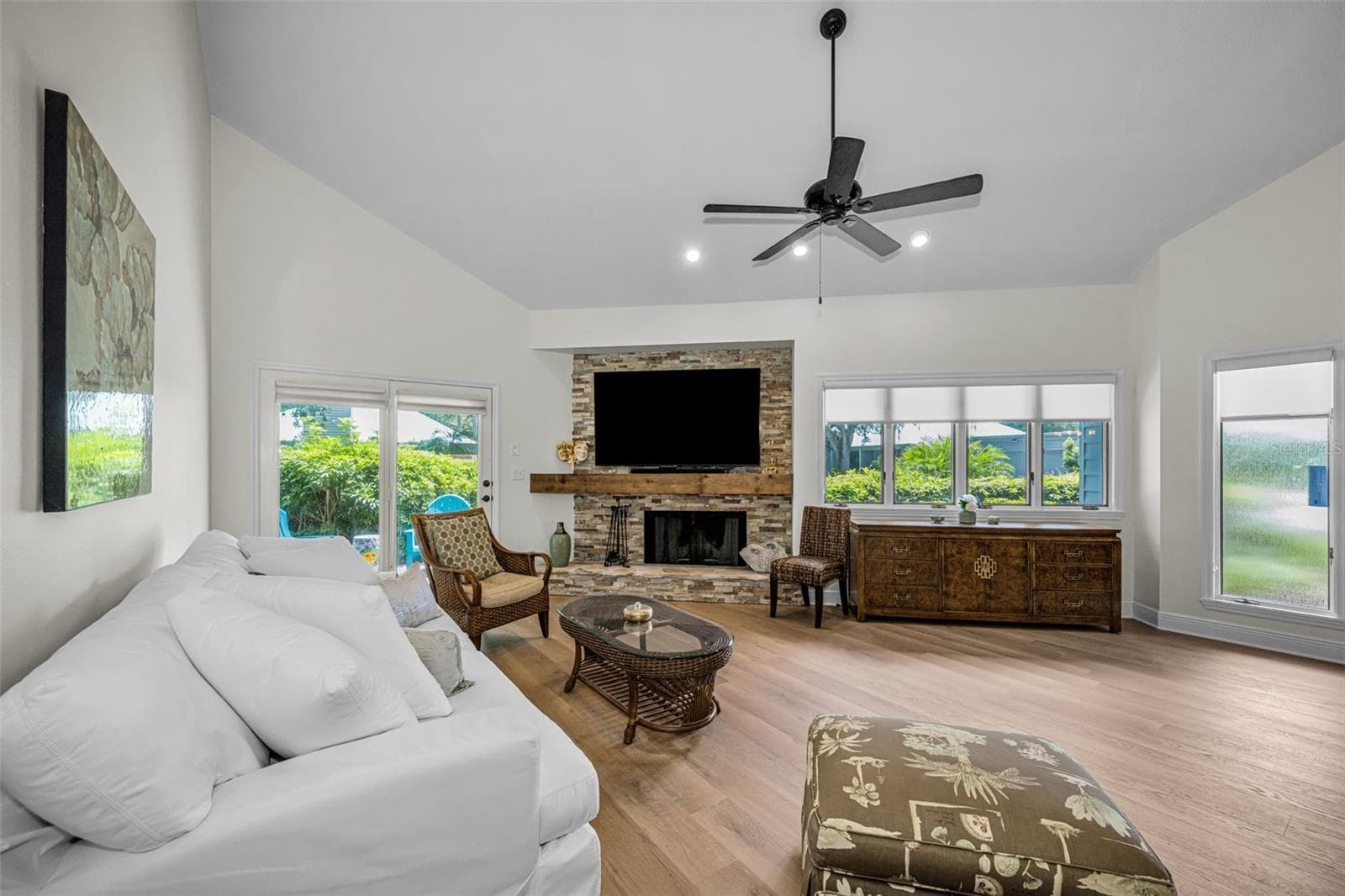Living room, new flooring,fresh paint, plus gorgeous stacked stone wood burning fireplace and so much natural light! - 10479 LONGWOOD DR, SEMINOLE