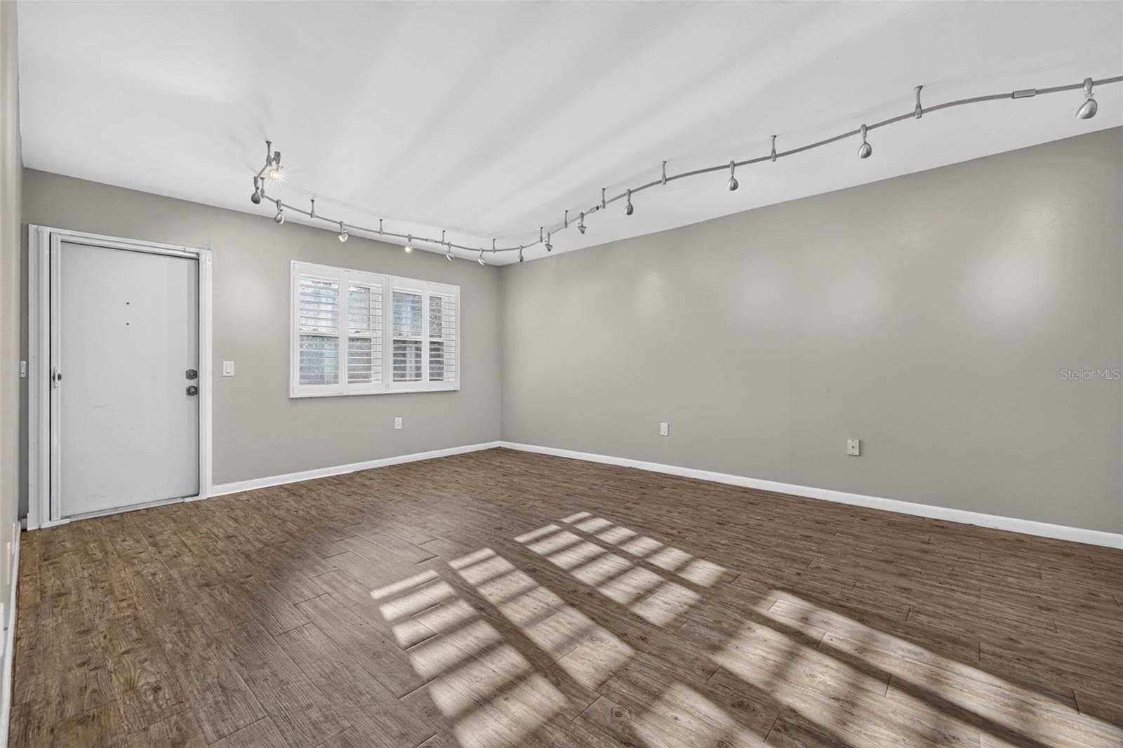 Spacious living room with luxury vinyl flooring, modern track lighting - 6015 19TH ST N #215, ST PETERSBURG