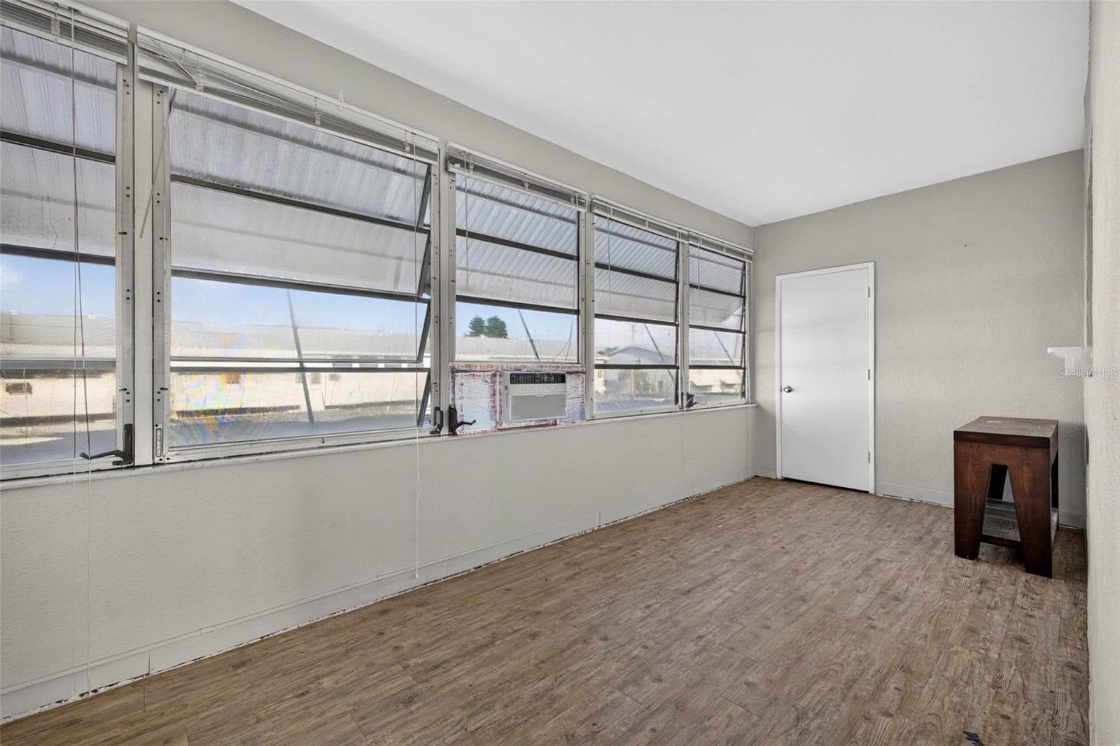 Bright enclosed Florida room with abundant natural light and flexible space for a home office, sitting area, or bonus living room. - 6015 19TH ST N #215, ST PETERSBURG
