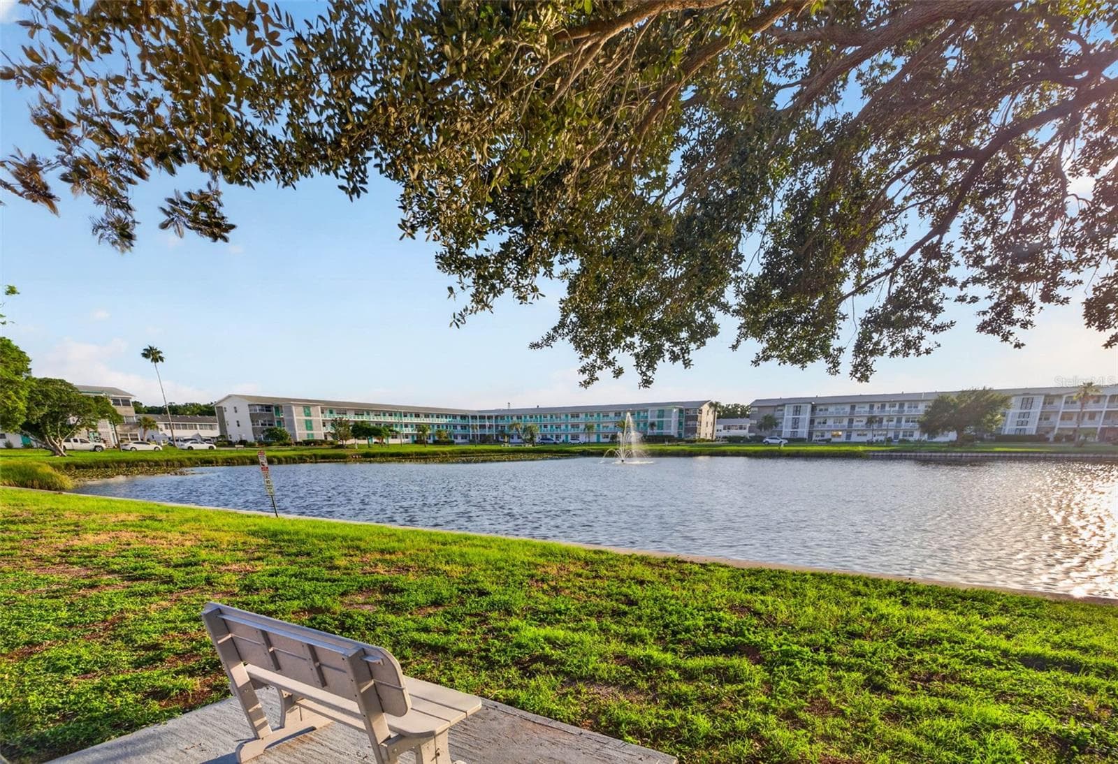 Scenic community pond with a tranquil fountain and peaceful green space. - 6015 19TH ST N #215, ST PETERSBURG