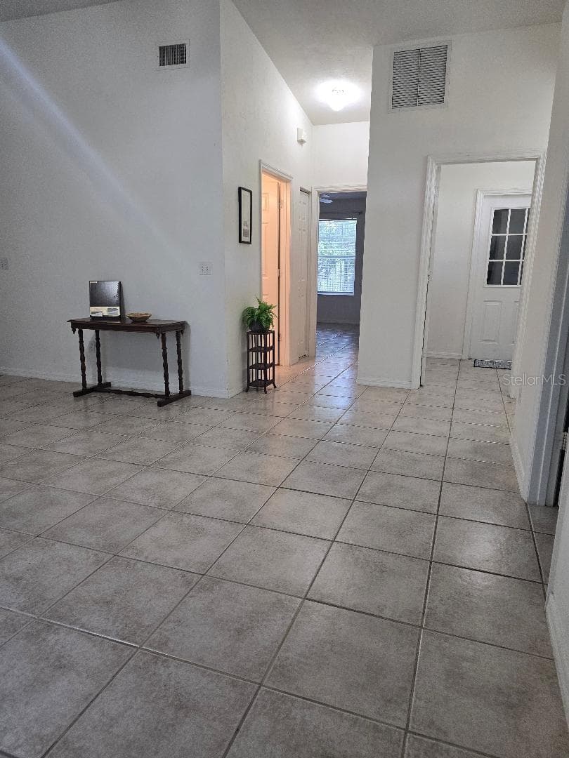 Living area to entry, hall to guest bath & 2nd bedroom in back & laundry room with garage door - 13607 NW 135 DR, ALACHUA