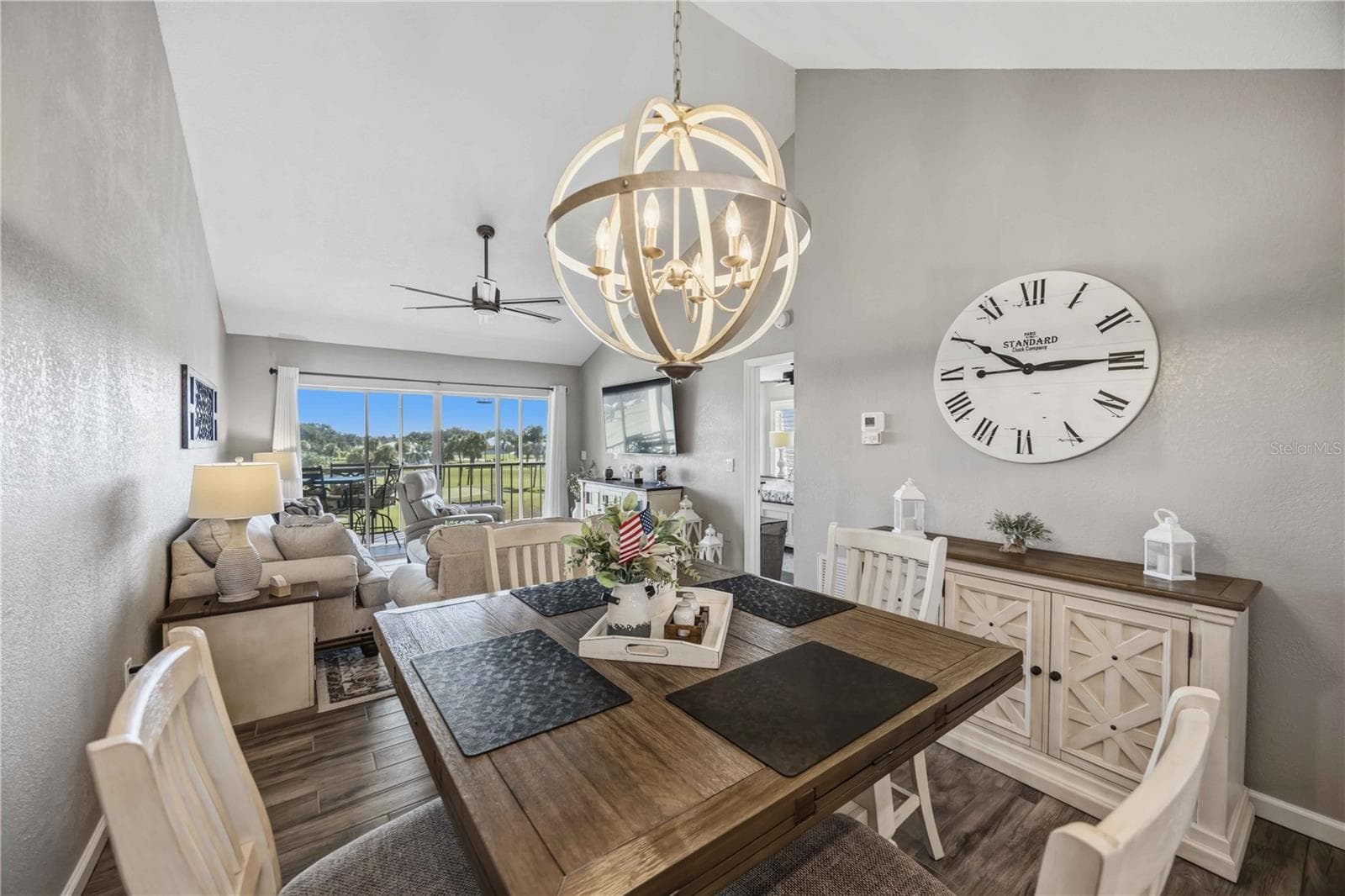 Open-concept living and dining spaces draw the eye toward expansive windows and the scenery beyond. - 406 CERROMAR CIR N #328, VENICE