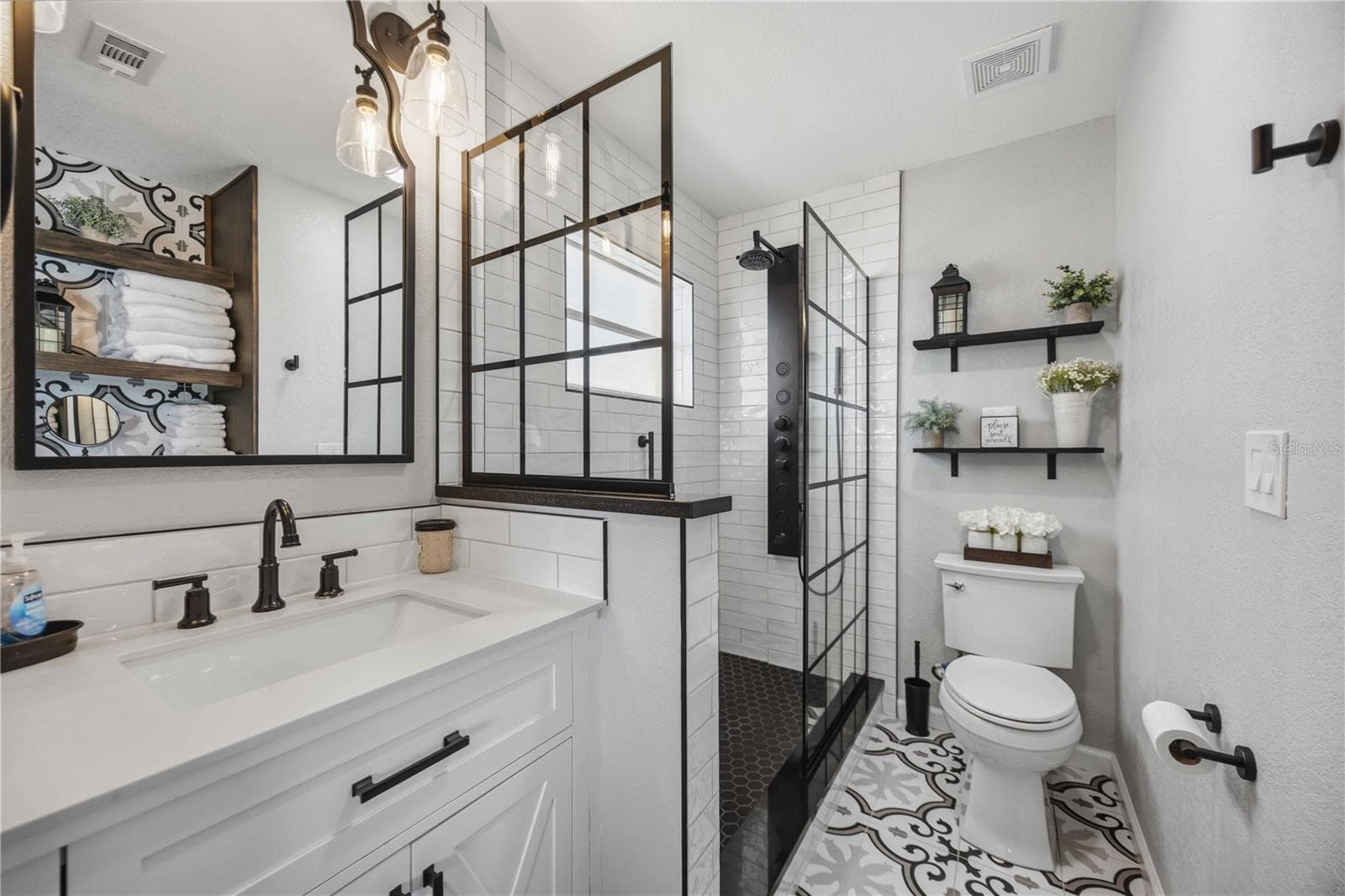 Beautifully renovated bathroom showcases a modern vanity, black fixtures and striking glass-enclosed shower. - 406 CERROMAR CIR N #328, VENICE