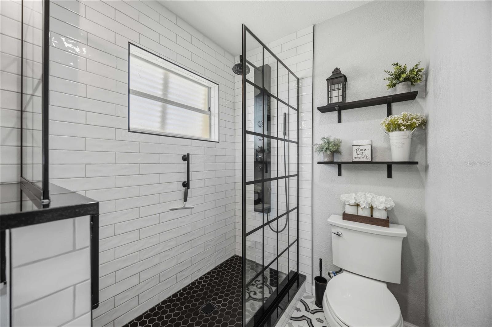 Spa-inspired shower features crisp subway tile, contrasting dark fixtures and a sleek glass enclosure. - 406 CERROMAR CIR N #328, VENICE