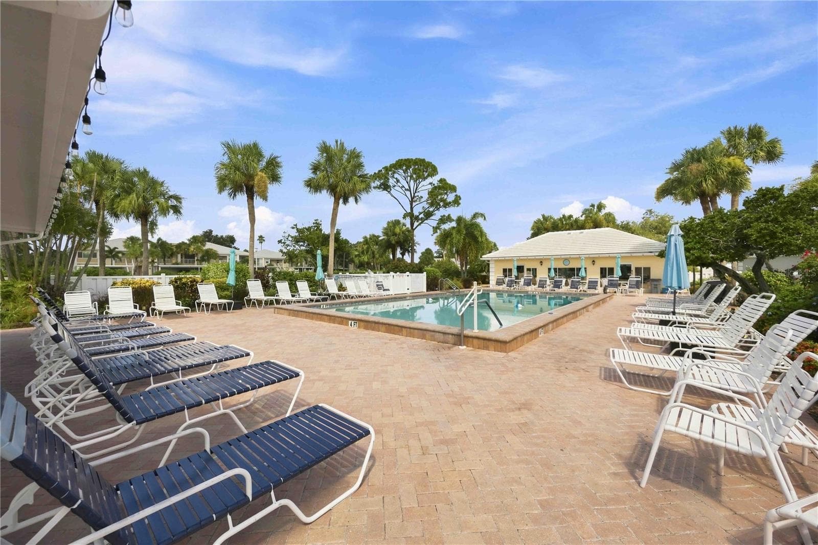 Sparkling community pool is surrounded by generous deck space, lounge seating and tropical scenery. - 406 CERROMAR CIR N #328, VENICE