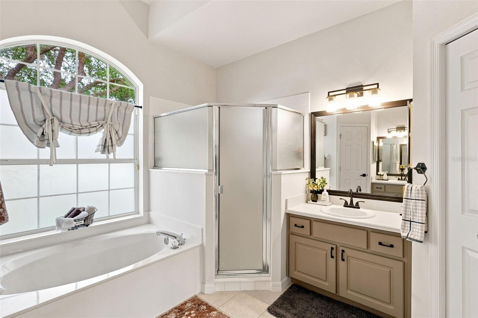 Primary ensuite bathroom with garden soaking tub and large walk-in shower. - 96 PARKVIEW DR, PALM COAST