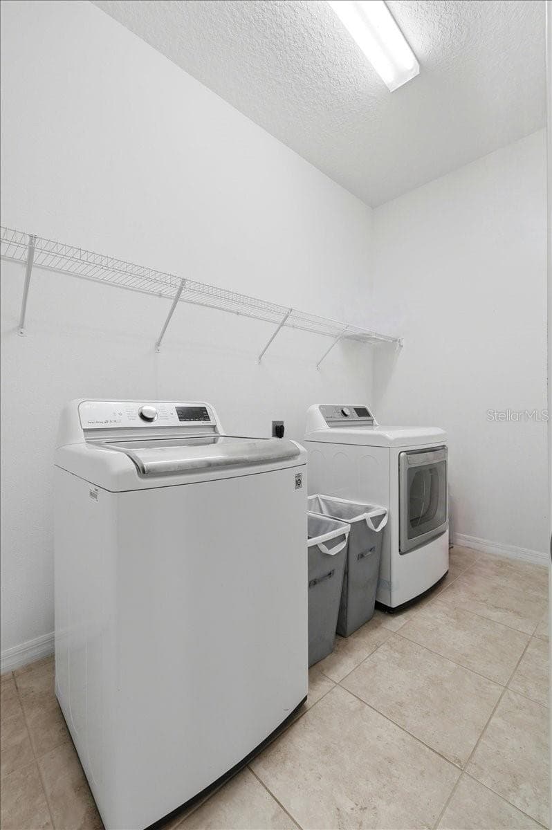 A dedicated laundry room with generous storage keeps everyday essentials organized, contained and effortlessly out of sight. - 4791 RIVERWALK DR, ST CLOUD