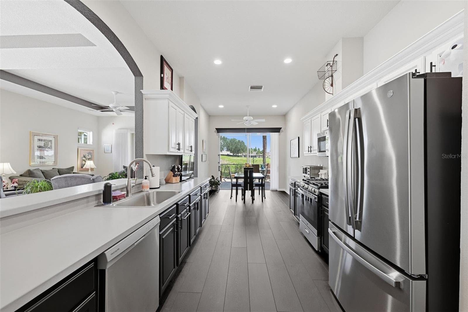 CHEFS KITCHEN WITH PLENTY OF COUNTER AND CABINET SPACE WITH GAS RANGE, SINGLE DEEP SINK. BREAKFAST NOOK WITH VIEW OF THE GOLF COURSE GREEN.  FLOORING IS LPV PLANK. - 441 NOBLE FAIRE DR, SUN CITY CENTER