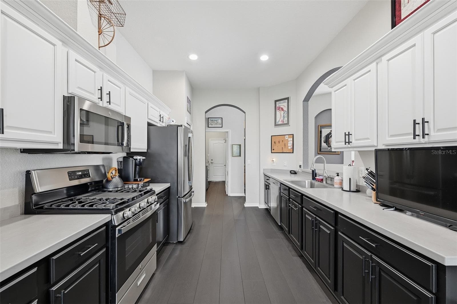 HIGH CEILINGS IN THE KITCHEN WITH TWO TONE CABINETS AND STAINLESS APPLIANCES. - 441 NOBLE FAIRE DR, SUN CITY CENTER