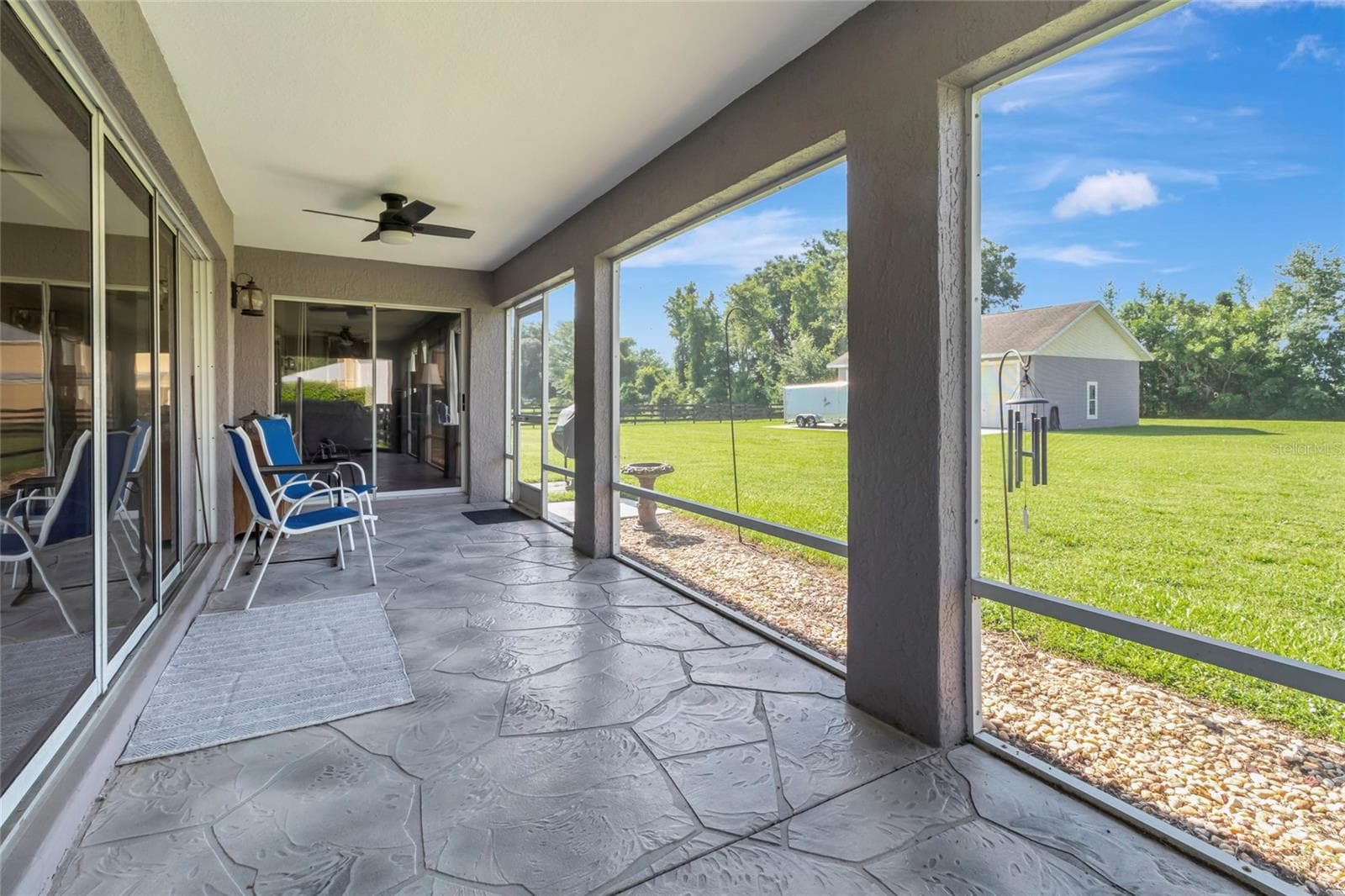 Large outdoor lanai off the back of this home overlooking the large 1-acre estate. - 4190 COUNTY ROAD 121D, WILDWOOD