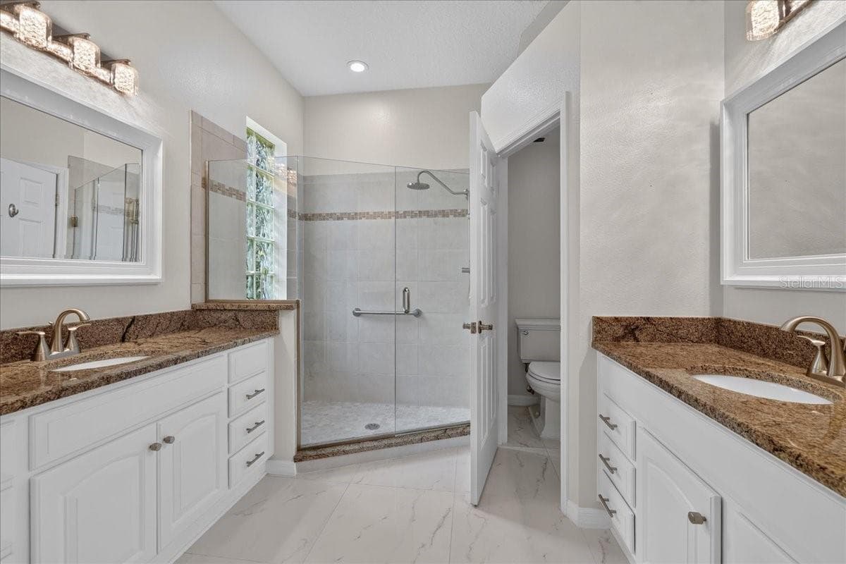 primary bath with glass block window in shower, and crystal light fixtures - 5 CAPTIVA AT LIONSPAW, DAYTONA BEACH