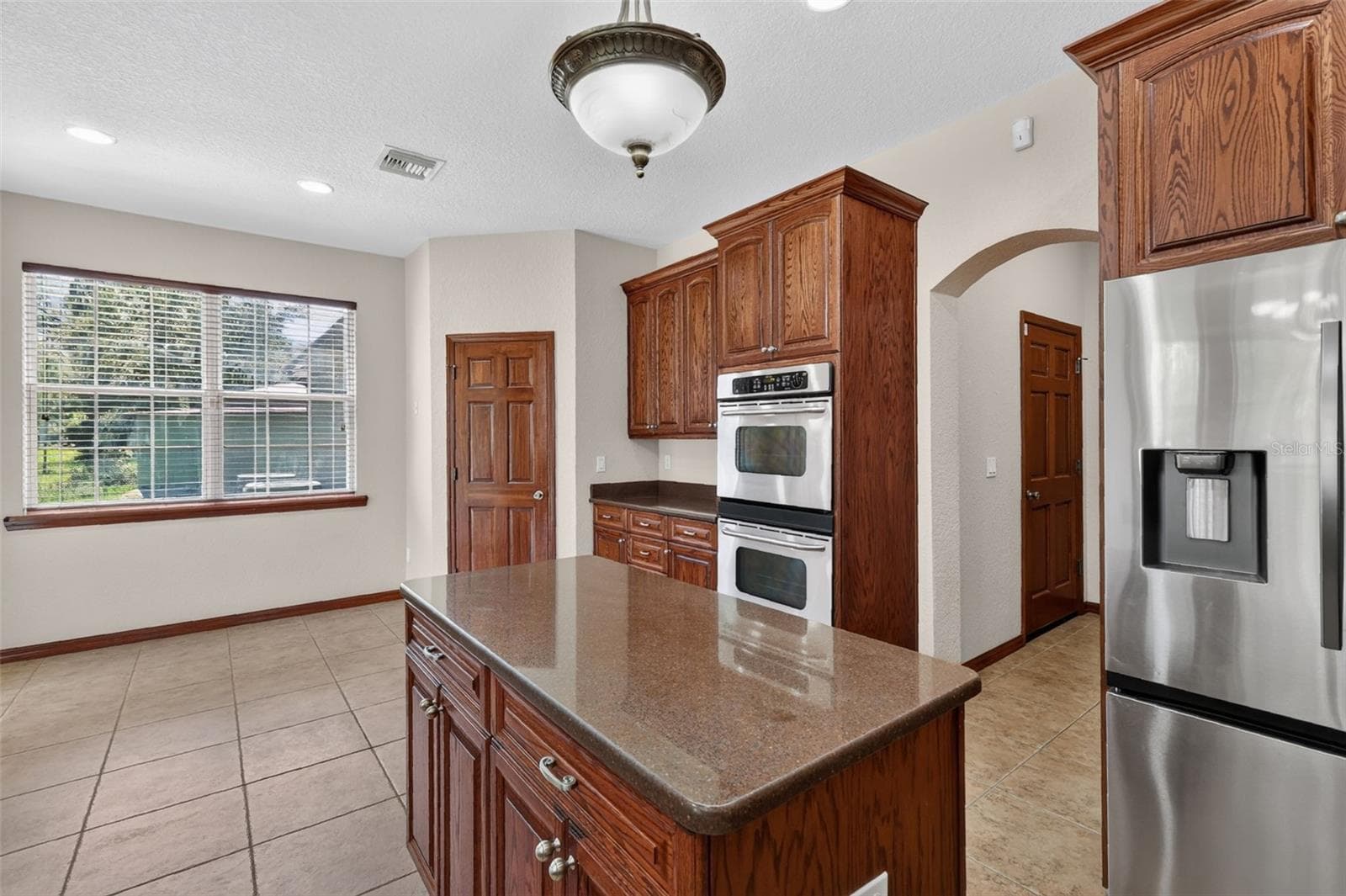 Generous solid surface countertops on the oversized island provide the perfect prep space for any occasion. - 4617 ROUND LAKE RD, APOPKA