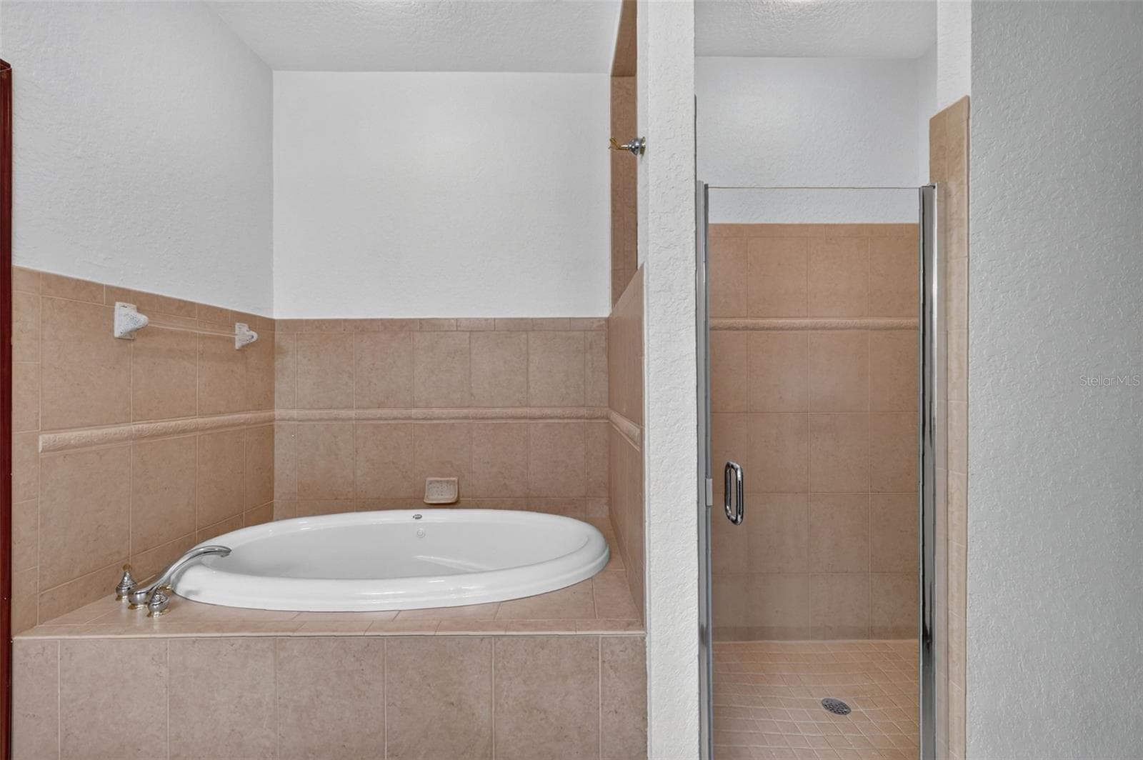 The primary bath offers the best of both worlds: a deep oval soaking tub and a fully tiled walk-in shower. - 4617 ROUND LAKE RD, APOPKA