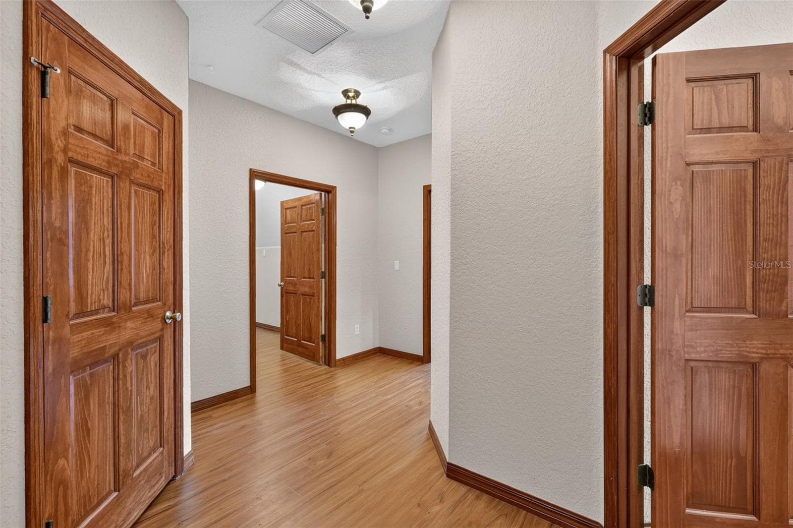 Upstairs, a well-appointed hallway with hardwood flooring leads to additional bedrooms, a full bath, and storage. - 4617 ROUND LAKE RD, APOPKA