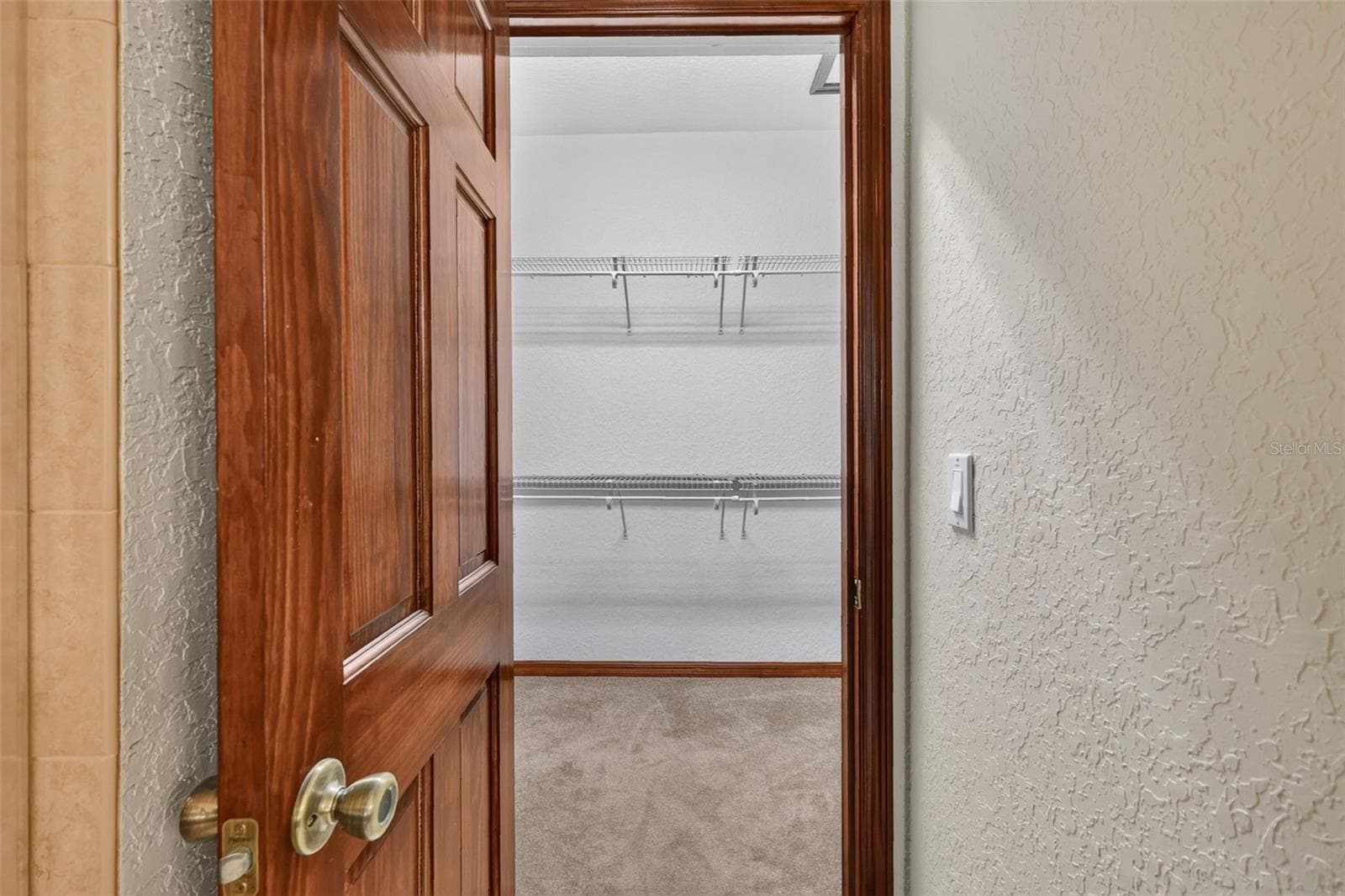 A spacious walk-in closet with built-in shelving keeps everything organized and within reach. - 4617 ROUND LAKE RD, APOPKA