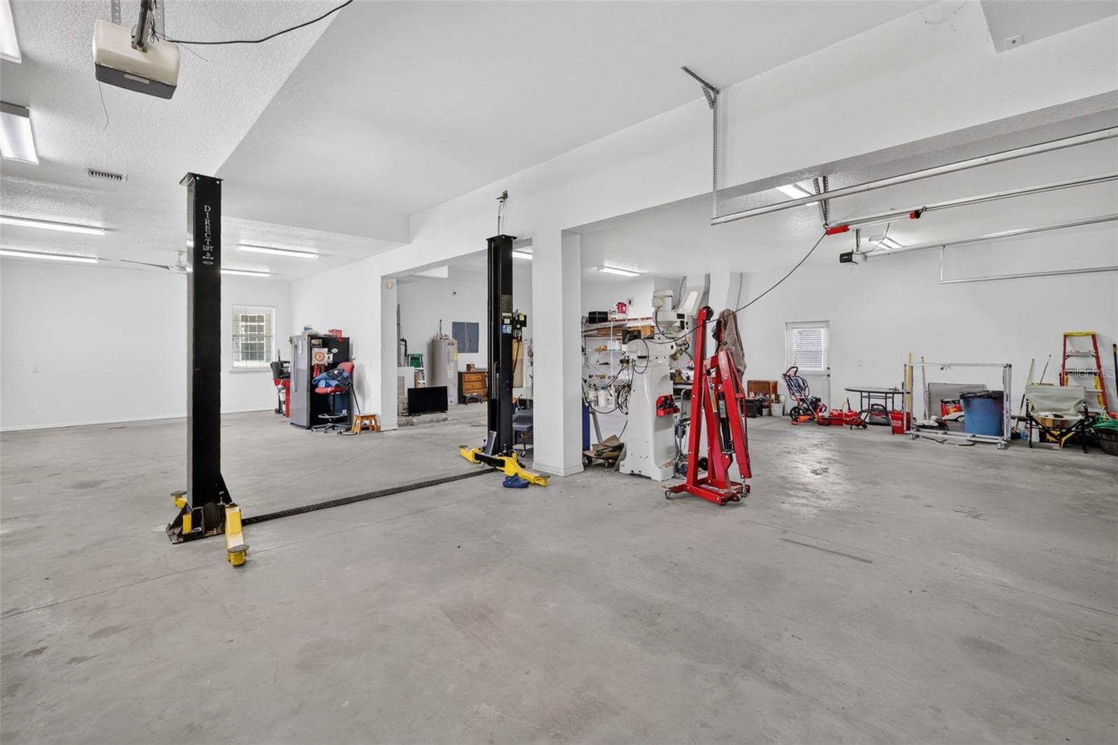 Car enthusiasts and hobbyists, take note: the detached outbuilding features a professional two-post car lift, soaring ceilings, and room for serious projects. - 4617 ROUND LAKE RD, APOPKA