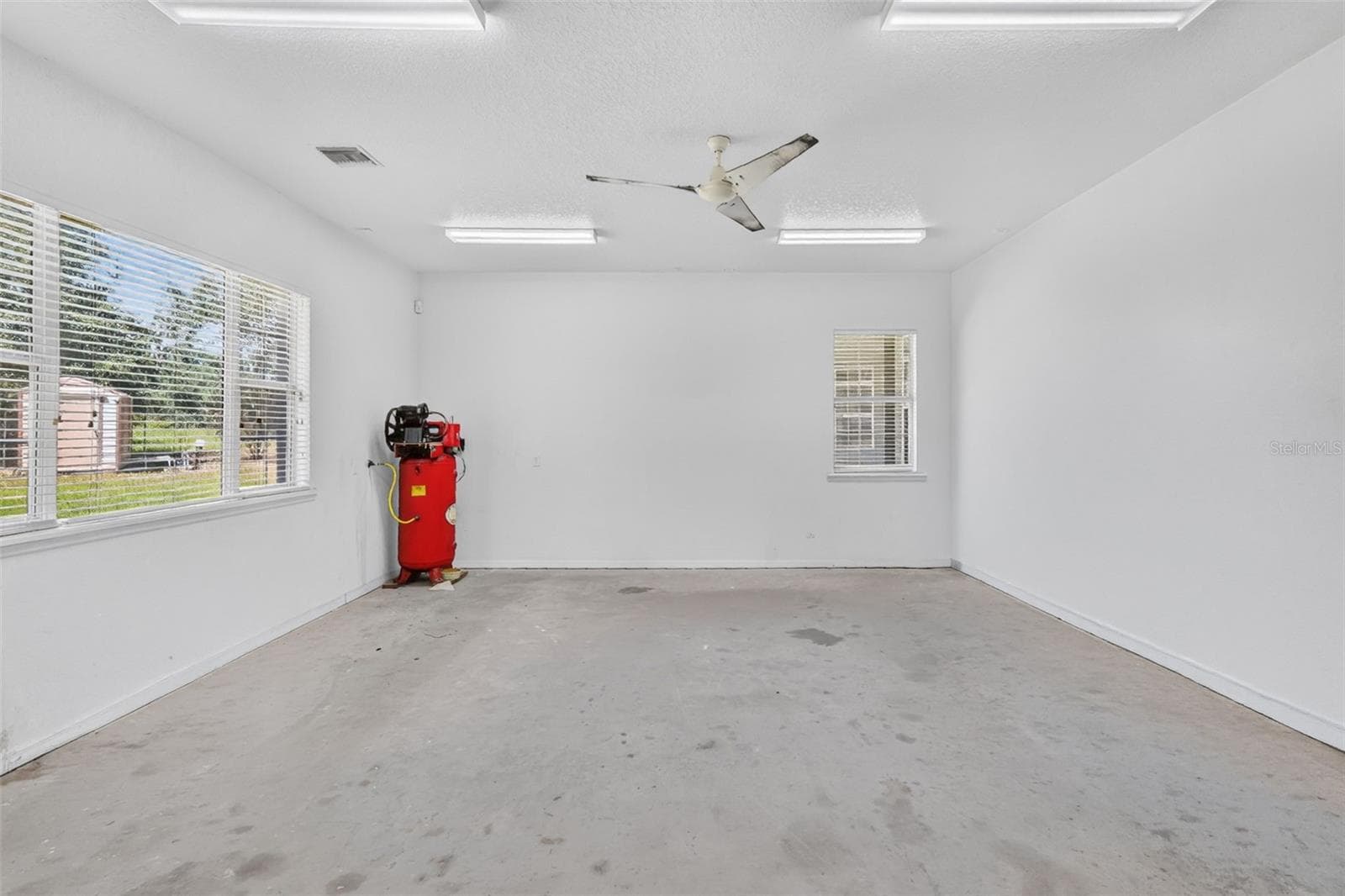An additional room houses the air compressor system and offers yet more flex space for storage, a gym, or studio. - 4617 ROUND LAKE RD, APOPKA