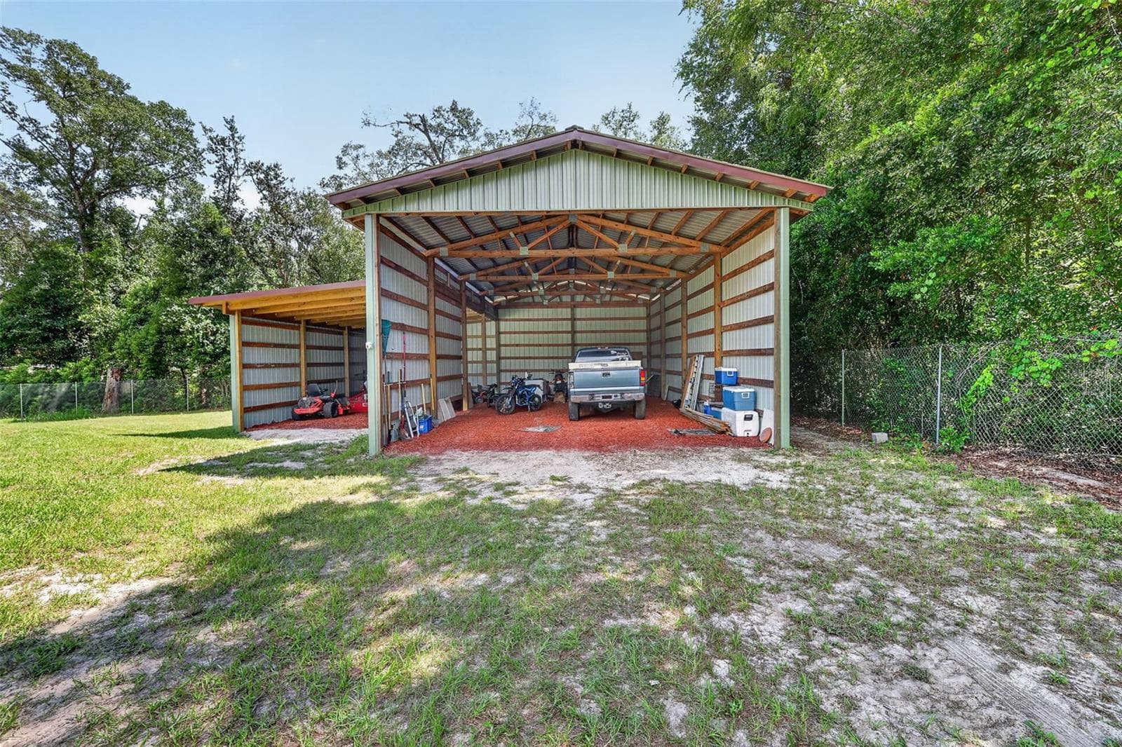 An additional covered pole barn provides protected storage for boats, RVs, trailers, ATVs, or farm equipment without taking up garage space. - 4617 ROUND LAKE RD, APOPKA