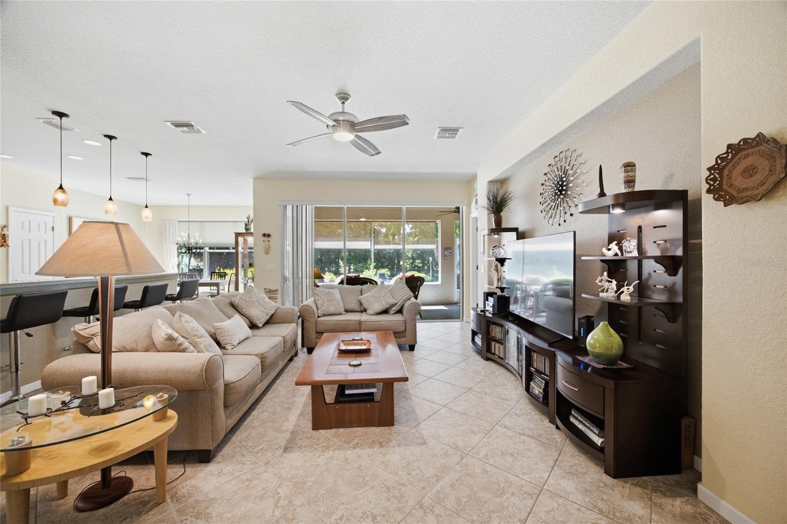Living room and sliding glass doors to screened in lanai - 9457 SW 66TH LOOP, OCALA
