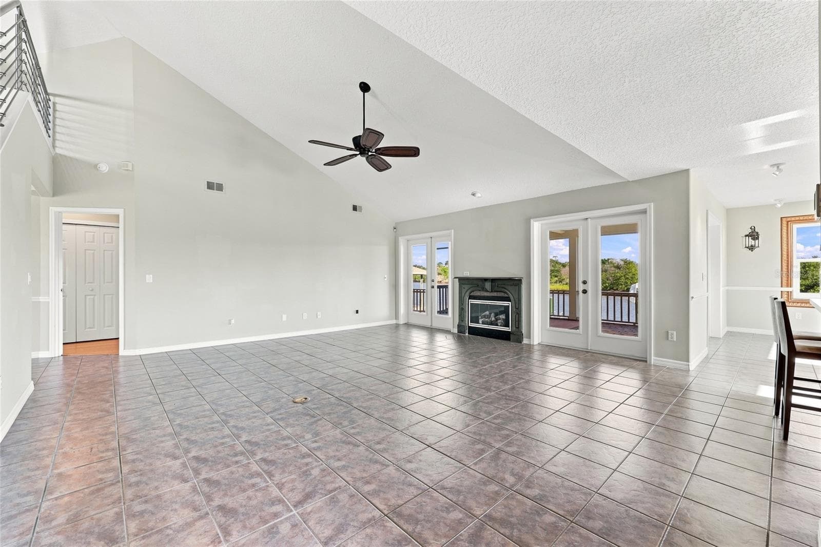 Great room — Vaulted great room with gas fireplace, French doors opening to twin water-view balconies, and tile flooring throughout. - 342 N 12TH ST, FLAGLER BEACH