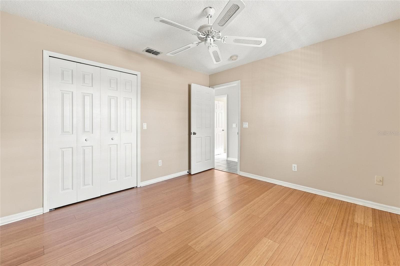 edroom — Bedroom with wood flooring, bifold closet doors, and a door opening to the hallway. - 342 N 12TH ST, FLAGLER BEACH