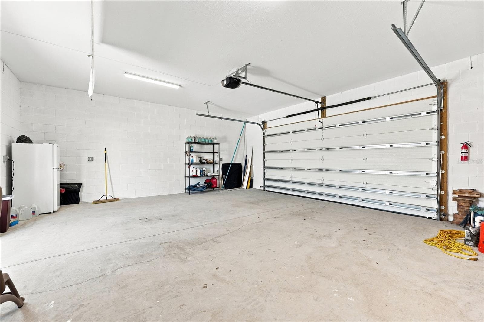 Detached garage — Detached garage with concrete flooring, overhead storage, and built-in wall shelving. - 342 N 12TH ST, FLAGLER BEACH