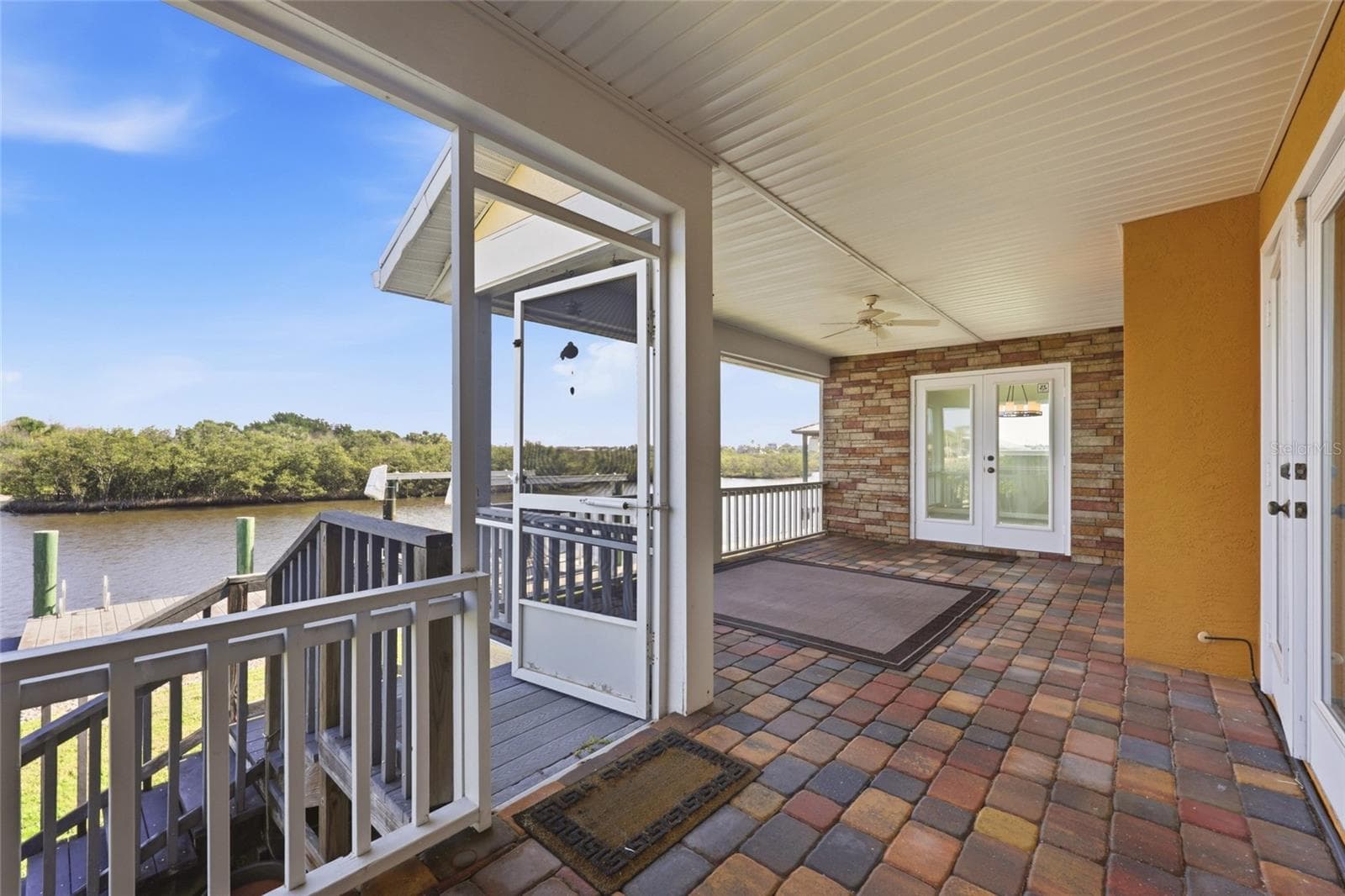 Screened porch — Screened porch with paver flooring, ceiling fan, French doors, and direct canal views. - 342 N 12TH ST, FLAGLER BEACH