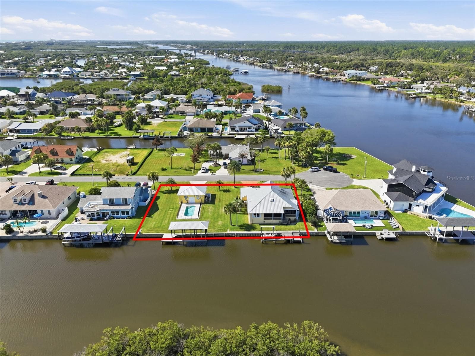 Aerial (property outline) — Aerial view with the property boundary outlined, showing the main house, detached 2-car garage, pool, and private dock with two boat lift areas on the canal. - 342 N 12TH ST, FLAGLER BEACH