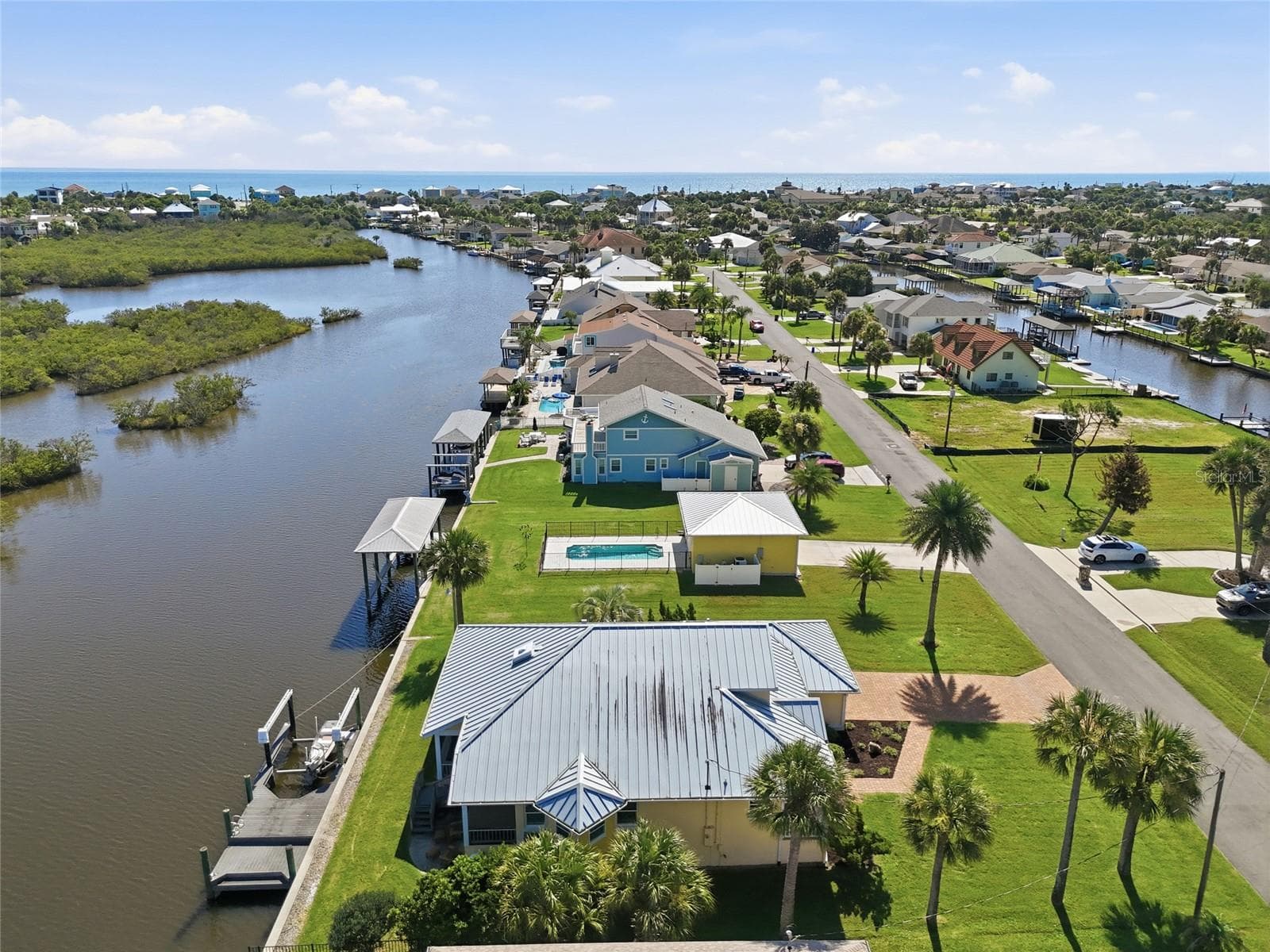 Aerial view — Wide aerial view of the canal-front property and surrounding waterway leading toward the Intracoastal Waterway and Atlantic Ocean. - 342 N 12TH ST, FLAGLER BEACH